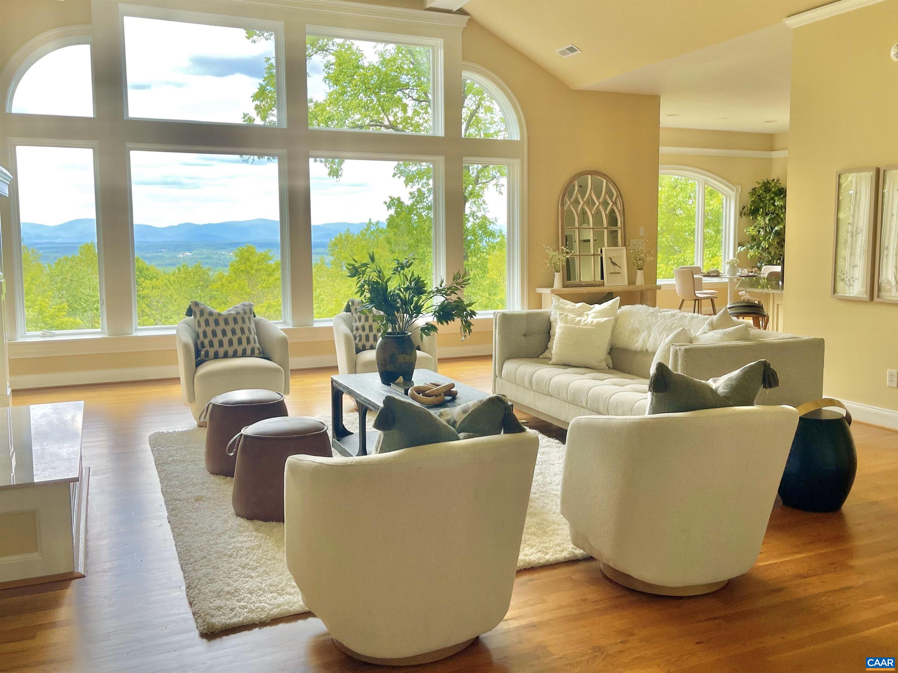 Spectacular Views and wonderful space in this 2007 custom designed 8400 sq.ft. home with many outstanding features. NEWLY UPDATED AND STAGED. Enjoy the luxuries which include a primary ensuite with fireplace and private deck with view, hand laid hardwood floors, additional fireplaces, built-in-cabinets, library, theatre room, family room with mini kitchen, rec/game room in basement roughed in central vacuum, elevator and three car garage. A spacious office over the garage with private entrance is current for today's buyer working from home.  Enjoy the natural beauty of the area and views from your covered porch and abundant decks.  A large home on a premium lot in a sought after community only 10 minutes to downtown Charlottesville.