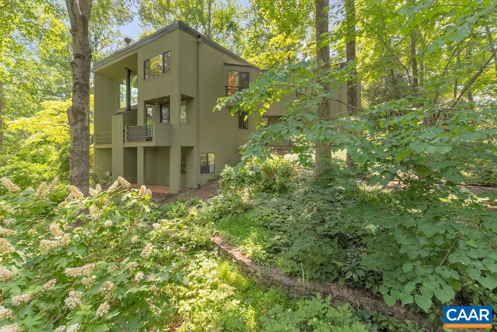 This Architect designed Ivy contemporary with separate office/ bonus room, and spacious studio workshop/garage, is an oasis in the middle of Ivy.  A plethora of perennials, shrubs and trees surrounded by  a lovely stream, bridge, stone walls and a pond with year-round wild life will capture your interest all seasons.   This truly magical property offers a soaring 2-story great room filled with natural light, fire place,  views of the gardens from every window, and opening unto the kitchen and dining room. On the second floor, you will find a spacious master bedroom with ante/dressing room and hall bath with heated floors, connecting to a multi purpose bonus room. The walk-out lower level offers a den / tv / sitting area,  2 more bedrooms and a full bath, again with heated floors. A separate exterior entrance leads to an office/ bonus room. The detached studio/garage  is partially heated and cooled and offers approx. 960 sq. ft of flexible space.  This property is Designed by Jack Rinehart AIA.  Improvements include : New roof, exterior paint, deck flooring,  water heater, kitchen appliances, washer, dryer, renovated bathroom, Pond drainage system, driveway gravel and much more. County records sqft. doesn't seem accurate.