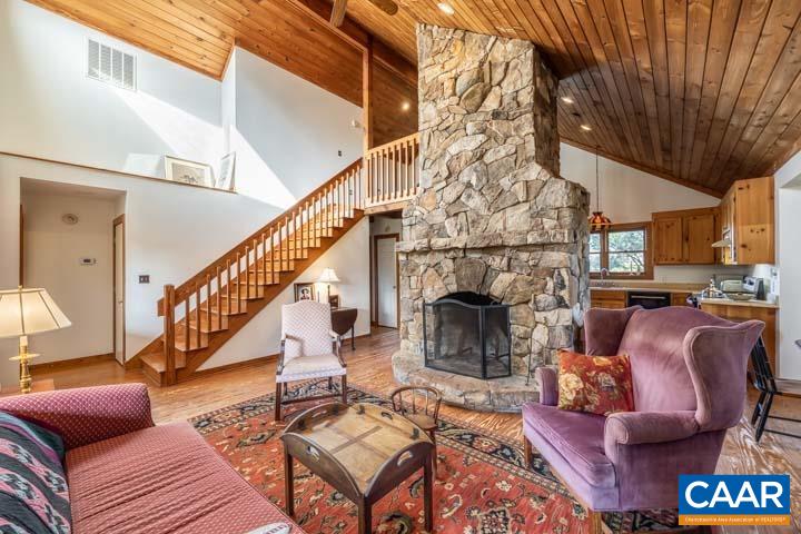 Charming country home on 21 gorgeous acres with stunning views. Private gravel driveway leads you to the homes welcoming front covered deck. When entering the home you will be greeted by 5" pine plank flooring,, great room with soaring ceilings also covered with pine planks, plenty of windows to let the sunshine in to enjoy the views, a massive stone fireplace that soars to the ceiling.  The interior of the home has been freshly painted within the last year.  New heat pump/AC was installed Nov 2021.  New stove being installed.  Master bedroom and bathroom on the first floor, upstairs loft is currently being used for an office but could also be used as a 3rd bedroom.  New deck has been added just off of the kitchen with stairs leading to the backyard, garden, firepit and trail to the pond and second barn. Bring your horses, donkeys, goats, and chickens!  The paddock, run-in barn, 2nd barn near the pond to store tools and hay, chicken coop with attached storage room, and a separate storage shed are all in place. Beautiful country living only just 20 minutes to Scottsville and 40 minutes to Charlottesville.  All 3 fireplace flues are cracked and being sold as-is.