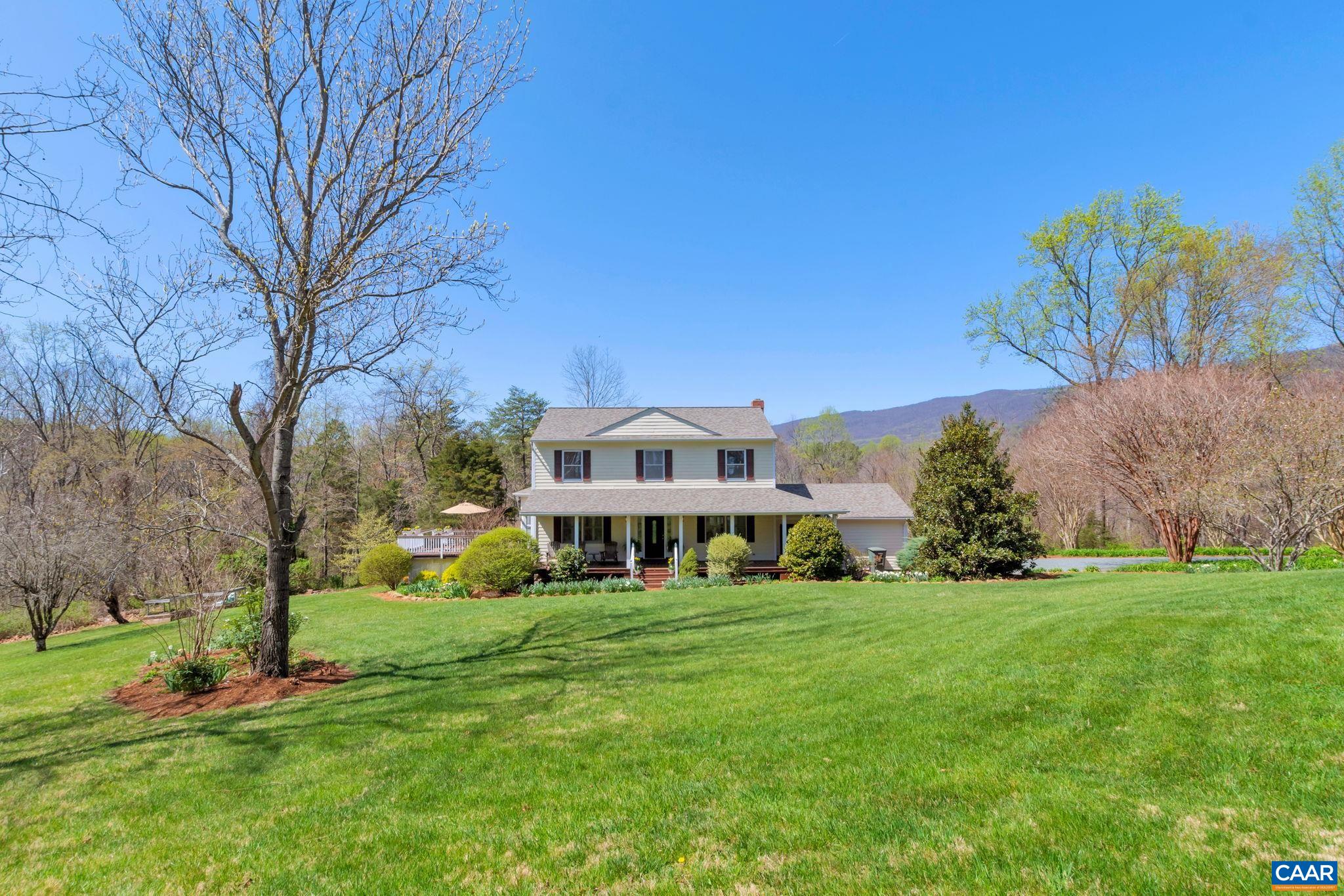 Charming and updated 4 bedroom farmhouse nestled on 4.74 private acres in Greenwood. The home is surrounded by HUGE Blue Ridge Mountain views, and the property is traversed by 530'+ of creek frontage. The updated home features 3 1/2 baths, hardwood floors, wood burning fireplace, front and rear (screened) porches, and a large terrace level family room. A newly (2022) remodeled kitchen, with stainless appliances, quartz counters, tile backsplash, large walk-in pantry, and stainless farmhouse sink. Large master bedroom with walk-in closet, remodeled attached master bath is fully tiled with radiant heat. First floor bedroom with attached bath could also serve as an excellent home office. Terrace level family room leads out to the arbored patio, which along with the 620sqft deck is perfect for family togetherness and entertaining. Wonderful grounds with stunning perennial gardens, flowering trees, open space for play, and a 12x24' electrified shed. And a "beach" by the creek! Newer roof, HVAC system, and whole house generator. Convenient to Western schools, Crozet shopping/dining, Charlottesville and UVA, the Valley, and local wineries, breweries, hiking, and so much more.