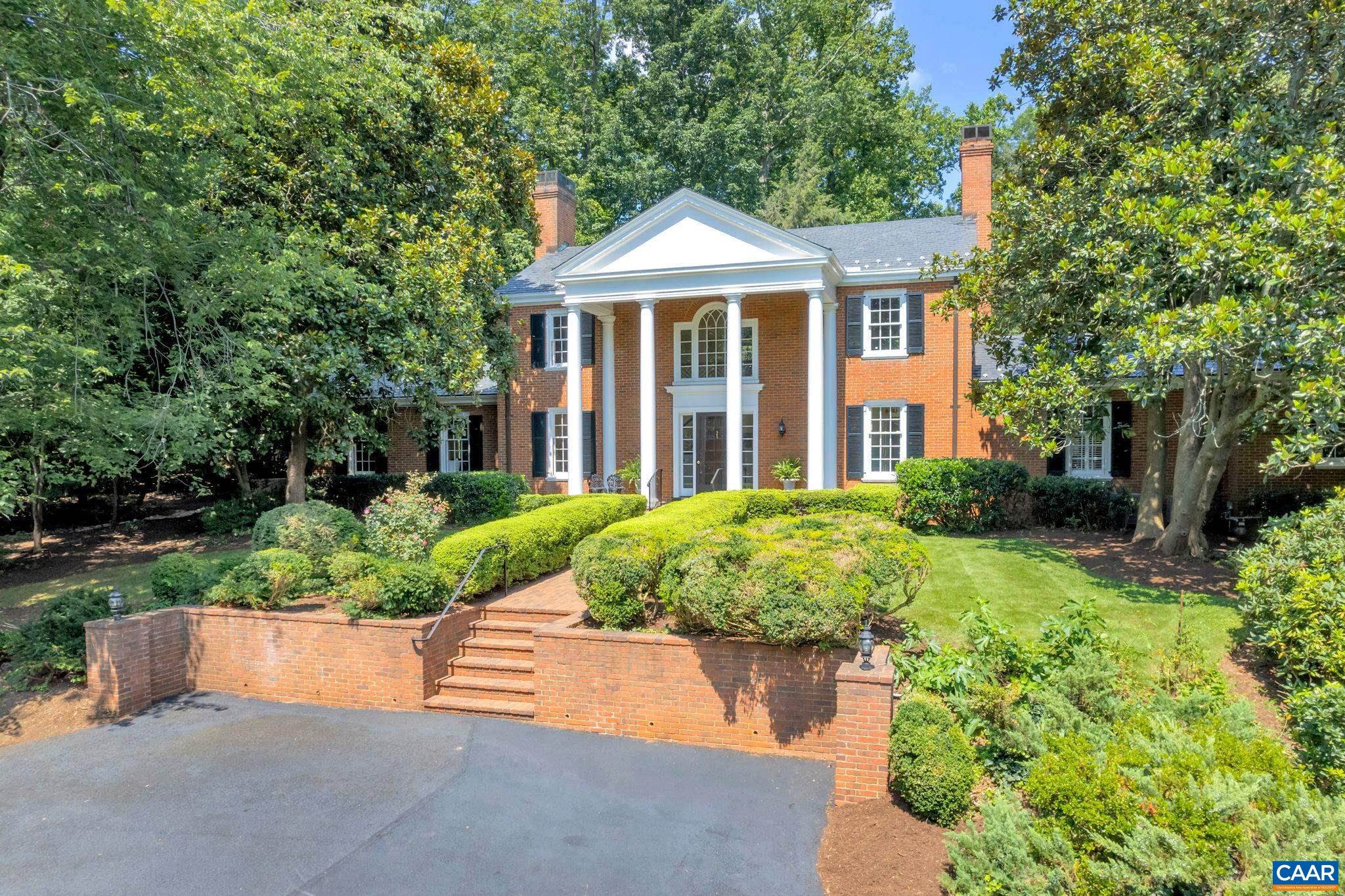 NEW PRICE! Classic 2-story brick home with slate roof and stately front porch boasts a commanding presence on Oak Circle in Albemarle County’s premier neighborhood, Farmington. The home is sited among towering magnolias, mature boxwoods, wandering paths, brick & slate walkways, colorful gardens and backyard Pool. Built in 1955, this custom designed/built one-owner home features traditional details, three wood-burning fireplaces, casual and formal living areas, sunroom, finished basement and hardwood floors. The main house offers 4 BRs + 4 full baths on 3 floors, plus attached, side entry 2-car Garage offers a charming guest suite above with private entrance, living area, kitchen, laundry, BR + full bath. Private nearly level backyard awaits your creativity: main house expansion, detached guest cottage, sport field, or private garden. Access the home from the front circular driveway or the secondary driveway which runs the perimeter of the 1.6 acre lot, allowing easy access by car, bike or golf cart. Savor the privacy of 440 Oak Circle while enjoying close proximity to Farmington’s sport courts, fitness center, delicious dining, Clubhouse activities, premier Golf and mountain views from the North Lawn.  Unique opportunity!