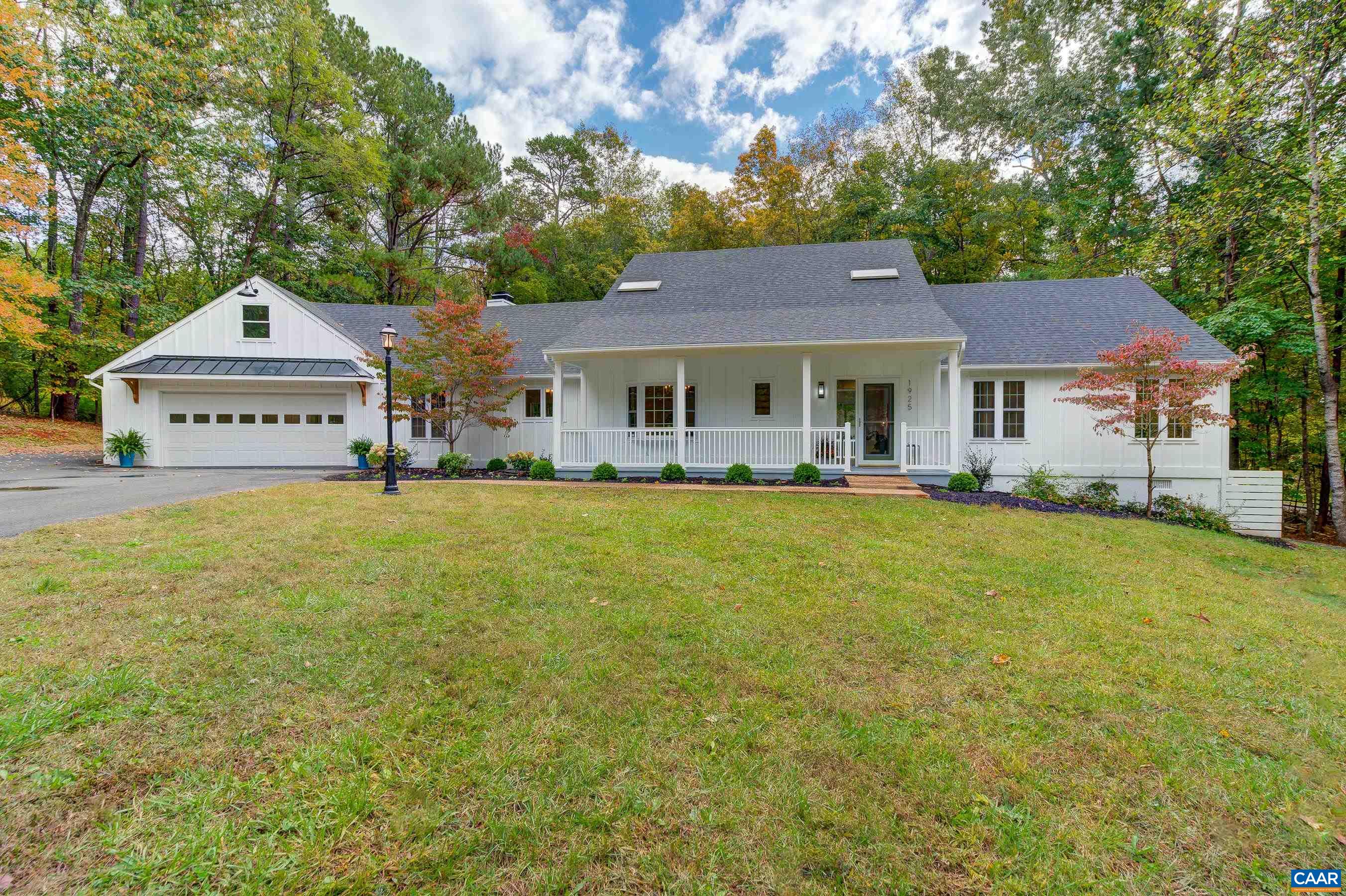 This recently renovated home in Ivy Farms situated on a serene 2+ acre wooded lot is a must-see for those seeking a blend of modern elegance and comfort. No expenses were spared in the redesign of this house, with refinished hardwood floors, high-end brushed gold light fixtures, and an abundance of natural light. The spacious living room and dining room create an inviting atmosphere. The kitchen is a chef's dream, featuring high-end stainless steel appliances, pristine white cabinets, and an waterfall granite island with seating that flows into the great room with gas fireplace and built-in bar equipped with a mini fridge and a commercial ice maker. The spacious main level primary bedroom provides a serene retreat, and the ensuite bathroom is truly spa-like. It boasts an oversized walk-in shower, a freestanding soaking tub, and a double sink vanity with a lighted mirror, offering a luxurious experience for daily routines. Upstairs, two additional bedrooms feature new ceiling fans, cedar lined closets and skylights and share a renovated hall bathroom. An expansive deck overlooks the generous lot with ample room for expansion or addition of a pool. The 2 car garage with epoxy floor features newly added floored storage above.