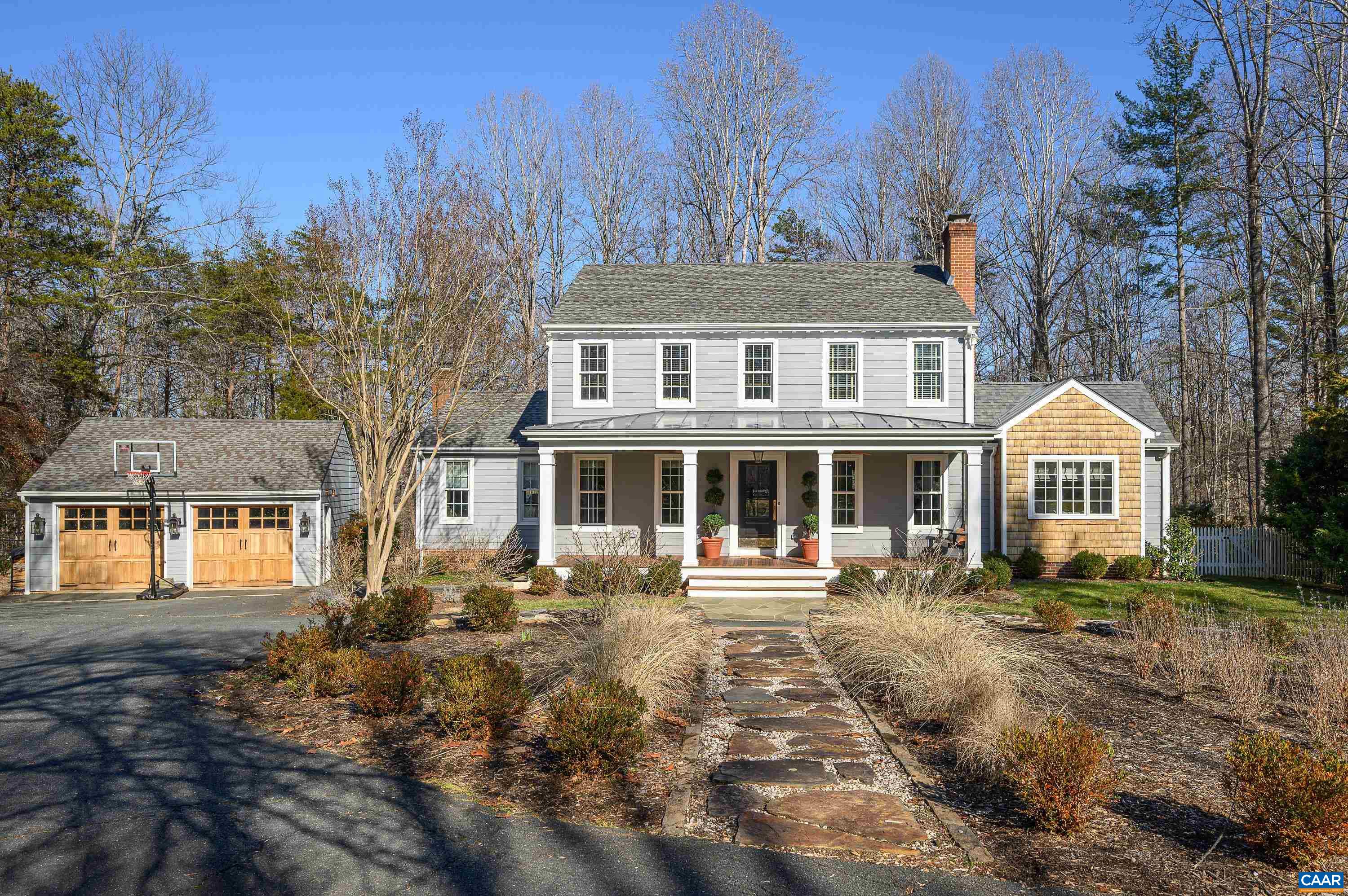 Sited on over 2 private acres in a popular Ivy neighborhood the current owners transformed this home with interior and exterior renovations including a first floor primary suite addition with access to an outdoor shower and private courtyard, new front porch and three season porch fitted with heater, fan and TV, rear deck with composite rails, bluestone patio, fully renovated kitchen with heated floors, new well pump, tank and water filtration system, tesla car charger and extensive finish upgrades.  The covered porch with ipe floors and metal roof opens into the home's foyer which leads into a dining room with wood burning fireplace. The owners converted an area off the dining room and kitchen to a cozy den with built-ins and desk area. The renovated kitchen has soft grey painted cabinetry, new appliances, soapstone island and sunny breakfast room and opens to a large vaulted great room with wood burning fireplace and built-ins.  The first floor primary suite addition includes vaulted ceilings, walk-in closets and a beautiful bathroom with designer finishes.  The second floor includes a second primary suite and 2 additional bedrooms and bath plus den. A detached garage with new doors  offers additional storage.