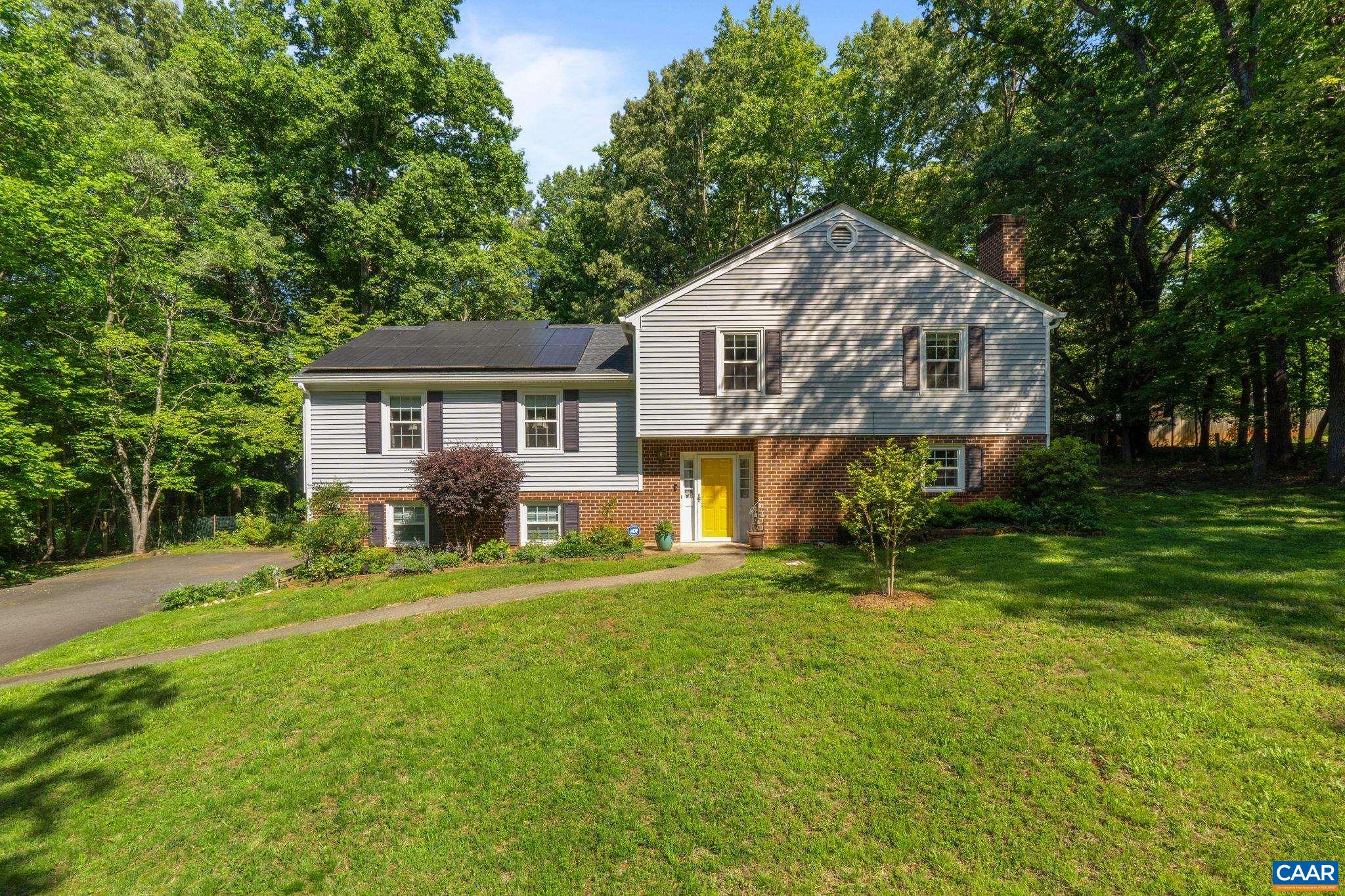 Charm abounds in this split-level four bedroom, three bath home on almost an acre in the heart of Ivy.  The welcoming foyer leads to a well-designed, light-filled family room, kitchen with a screened-in porch, and back deck overlooking the backyard.  Unwind in the ground level sitting room with fireplace, as this floor also boasts a bedroom with a full bathroom. Upstairs consists of the primary bedroom and bathroom,  and two additional bedrooms with a full bathroom. Well-maintained hardwood floors are throughout the entire home.  Thoughtful upgrades include new kitchen appliances, gutters, alarm system, new roof (2022), and solar panels which significantly reduce power costs. Bonus features include a two-car garage with side entrance and a home generator.  Take advantage of outdoor living in this quiet, low traffic neighborhood and enjoy a rarity: a nearly level lot in Ivy! The back porch opens up to ample space perfect for a garden, swing set, sports field, or outdoor entertaining area. Access the neighborhood connecting trails of Narnia or enjoy the peaceful neighborhood circle. Close proximity to Duner’s, Blue Ridge Swim Club, and Ivy Elementary.