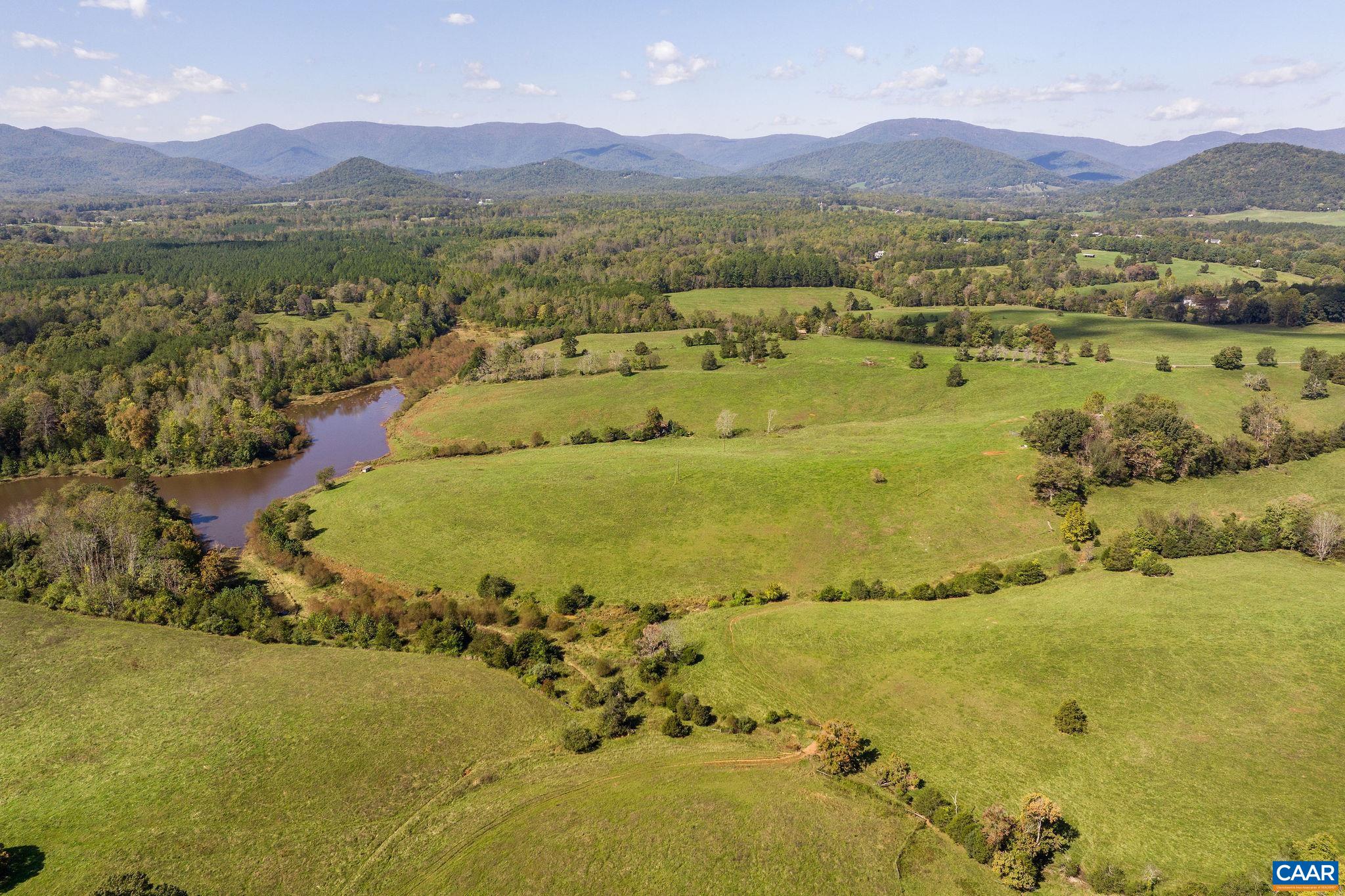 Named for its geographic relation to a nearby sister farm, The Upper Farm spans 595 acres in Albemarle County with sought-after Blue Ridge Mountain views. The property features a 20-acre lake, over half a mile of road frontage, and a blend of rolling pastures and mature woodlands, offering numerous homesite options. Located just 14 minutes from the Charlottesville Albemarle Airport and a little over 25 minutes to UVA, this property uniquely combines scenic seclusion with convenient access. With 12 distinct parcels and an existing farmhouse that can be utilized or reimagined, The Upper Farm is primed for diverse opportunities—from agricultural ventures to creating an exceptional recreational retreat. Additional acreage across Simmons Gap Road is also available for expanded possibilities.
