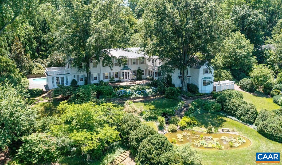 Lovely stone residence in Farmington Country Club with sweeping Blue Ridge Mountain views. Built in 1930 with tasteful additions, this charming and elegant house offers 5 bedrooms, living room, dining room, chef’s kitchen, study, and an orangery. The quiet private 5 acre property includes a two-story guesthouse with kitchen and 1.5 baths, a separate, second, guest house or office with full bath and fireplace, a large, detached garage, pool, koi pond and garden sheds. There are stone terraces walkways, garden walls and fountains. The professionally landscaped grounds with native plantings offer unusual privacy with convenience to town, UVA and the many amenities of the Club: including golf, tennis, pool, fitness center, and fine dining. Primarily one room deep the residence has excellent light and exhibits fine details and great craftsmanship throughout. This is a special property, comfortable, elegant and to be treasured. Close to the Club. .