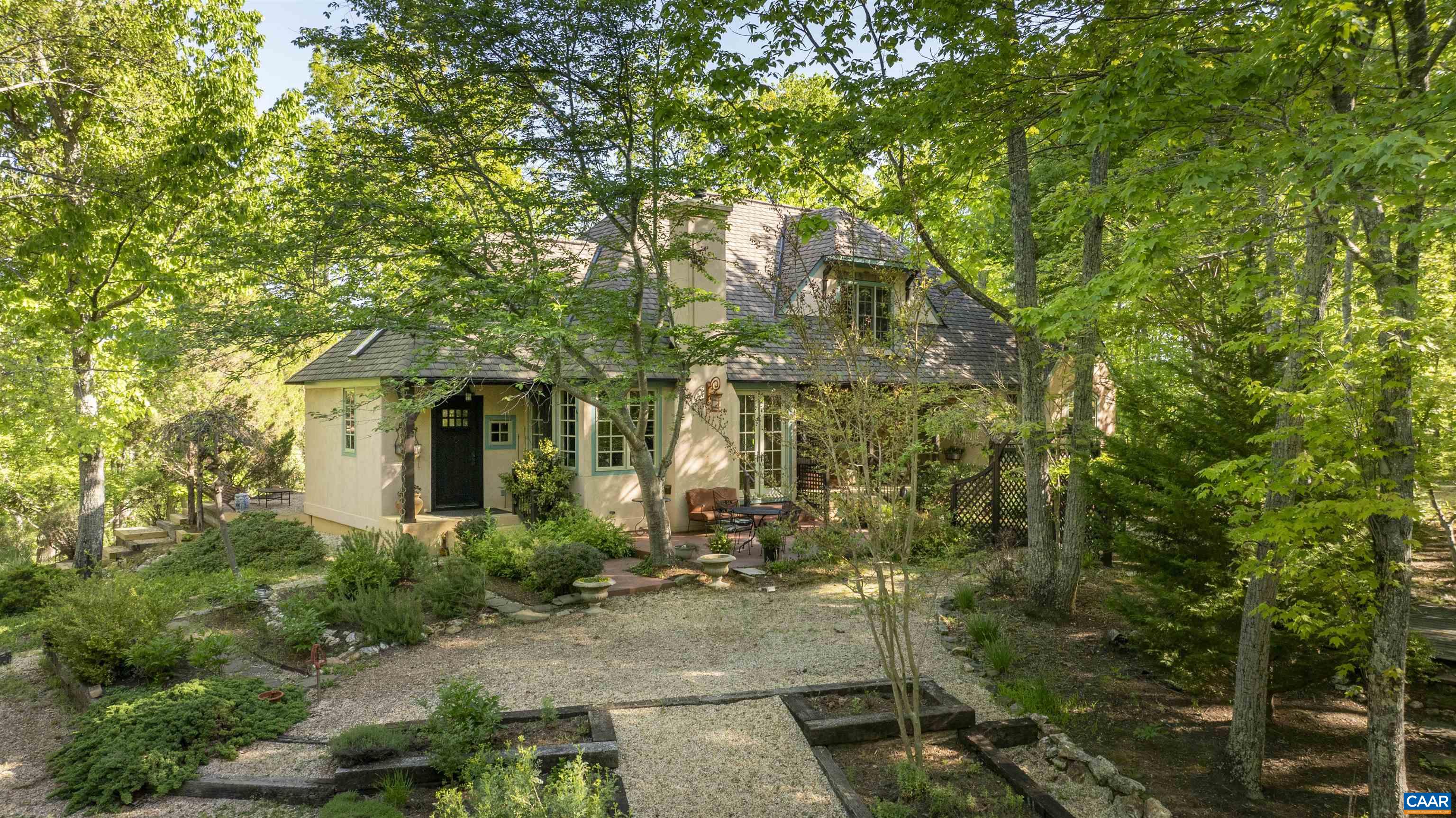 This exceptional Timberpeg hybrid home embodies the ‘not-so-big’ philosophy while offering all the amenities discerning buyers expect. Set on almost 35 wooded acres, 2.6 miles from the Howardsville Boat Ramp on the James River and half a mile from the Rockfish River, this retreat offers privacy and craftsmanship. The timber frame creates an architectural masterpiece with decorative painting, stucco exterior, and gardens. European design elements abound, with a cathedral ceiling in the living room drawing the eye upward, and a classical mantel over the travertine fireplace serving as a focal point. Custom wood doors and arched windows add charm to every space. The chef’s kitchen boasts an arched cooking hearth, travertine sink, and a spacious island with an overhead pot rack, enhancing everyday cooking. A studio above the garage offers an inspiring retreat, while a log cabin guest house provides visitor accommodations. The property features fenced horse pastures, a barn, private trails, and a tranquil pond with natural springs, boulders, and stone patios. Built in 2005, this property is perfect for weekends or remote work, supported by high-speed underground fiber internet. Additional division rights available.