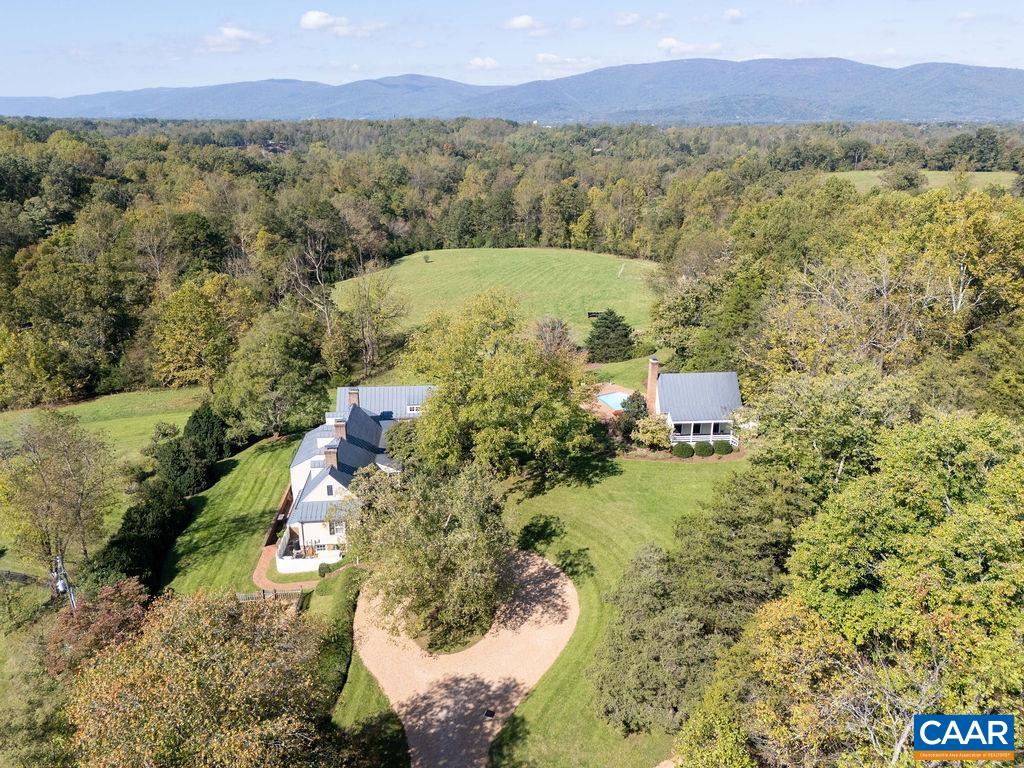 Temple Hill c. 1790 is an extraordinary revolutionary era estate in Western Albemarle comprised of 10.35 scenic acres. An exceptional & rare offering that has been thoughtfully renovated & expanded to incorporate modern luxuries while maintaining the property's historical integrity. Temple Hill offers breathtaking mountain and pastoral views, creating a picturesque backdrop that changes with the seasons. The main residence offers 4 bedrooms, 4 full + 2 half baths & 2 home offices. The guest cottage also serves as a pool house with a full kitchen & bath directly off of the pool for convenient entertaining. Located in Ivy with easy access to Rt250 & I64, ~7 min to Crozet, 10 mins to Boars Head & Farmington & 10mi to UVA. Property features 5 working fireplaces, wide antique heart pine flooring, hand hewn exposed beams, vaulted ceilings, bricked patios, covered porches, pool, sports/tennis court, detached 2 bay garage, fenced paddock, equipment shed with feed room & option for 1 level living with 1st floor level primary suite. Part of the 2010 garden tour, Temple Hill enjoys beautifully landscaped grounds with formal gardens, cutting garden, and 100 year+ boxwoods.