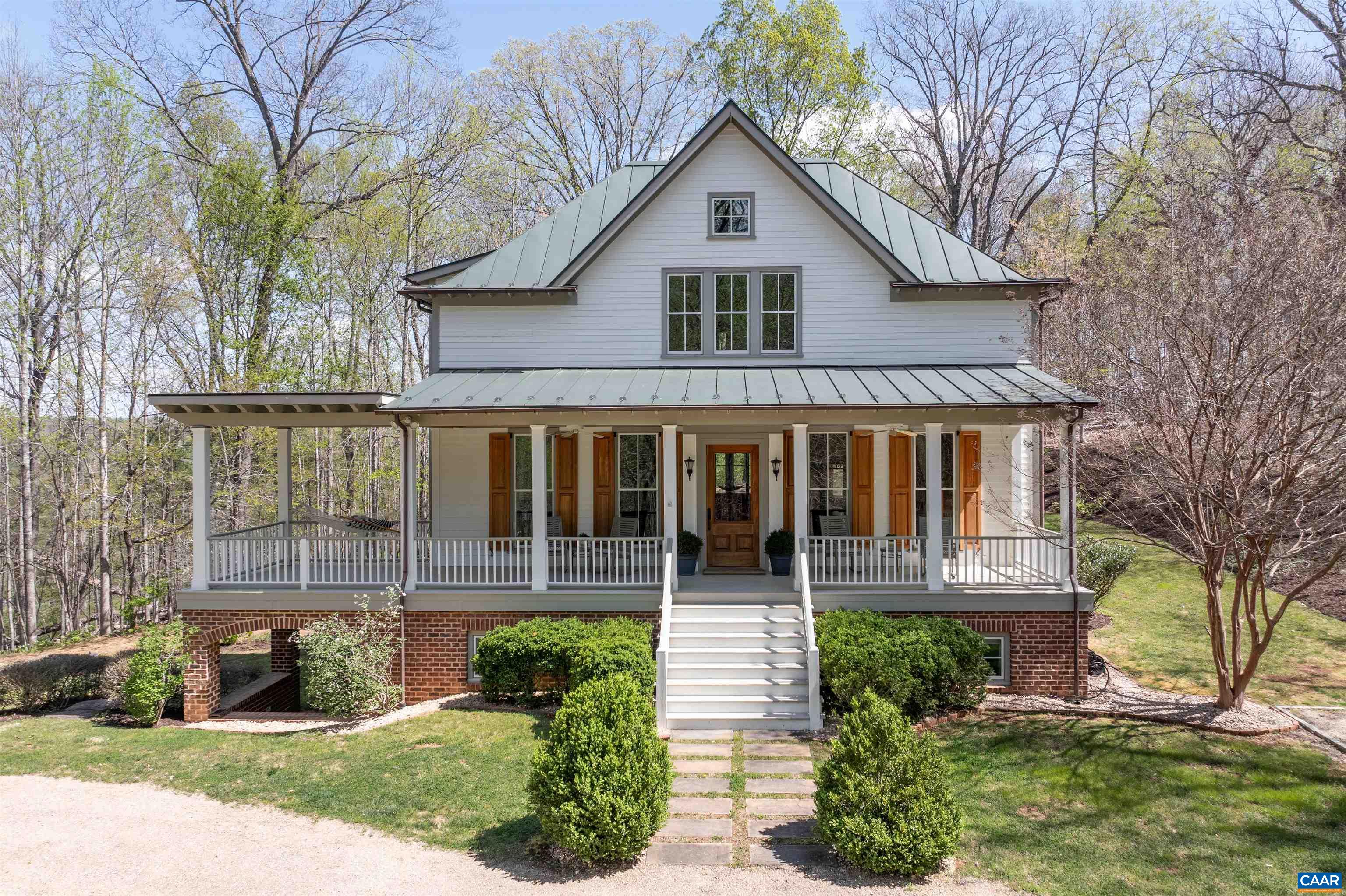 Sited on over 23 exceptionally private acres with mountain views, this Peter Johnson built, quintessential Virginia farmhouse perfectly captures today's taste for bright, open living spaces warmed by striking accents that create a sophisticated, yet cozy feel. Step inside & prepare to be wowed by beautiful hardwood floors milled from trees from the property, stunning ceiling beams recovered from a Pennsylvania bank barn, and a handsome reclaimed wood and soapstone island that is the centerpiece of the kitchen.  Floor to ceiling windows flood the home with natural light, while a dramatic stone Rumford fireplace in the great room offers a focal point for family gatherings.  The idyllic setting is highlighted by brick and stone walls and patios, and multiple outdoor spaces for enjoying the solitude.  Though current owners have enjoyed this property as a relaxing getaway their intention had always been to add a primary suite for more permanent living.  All systems, including septic and geothermal HVAC, are sized to accommodate an addition.  Built to exacting standards & meticulously maintained, this stunning property is just 20 min. to C'ville airport, 15 min. to Downtown Cville, Martha Jefferson & UVA Hospitals, & UVA Grounds.