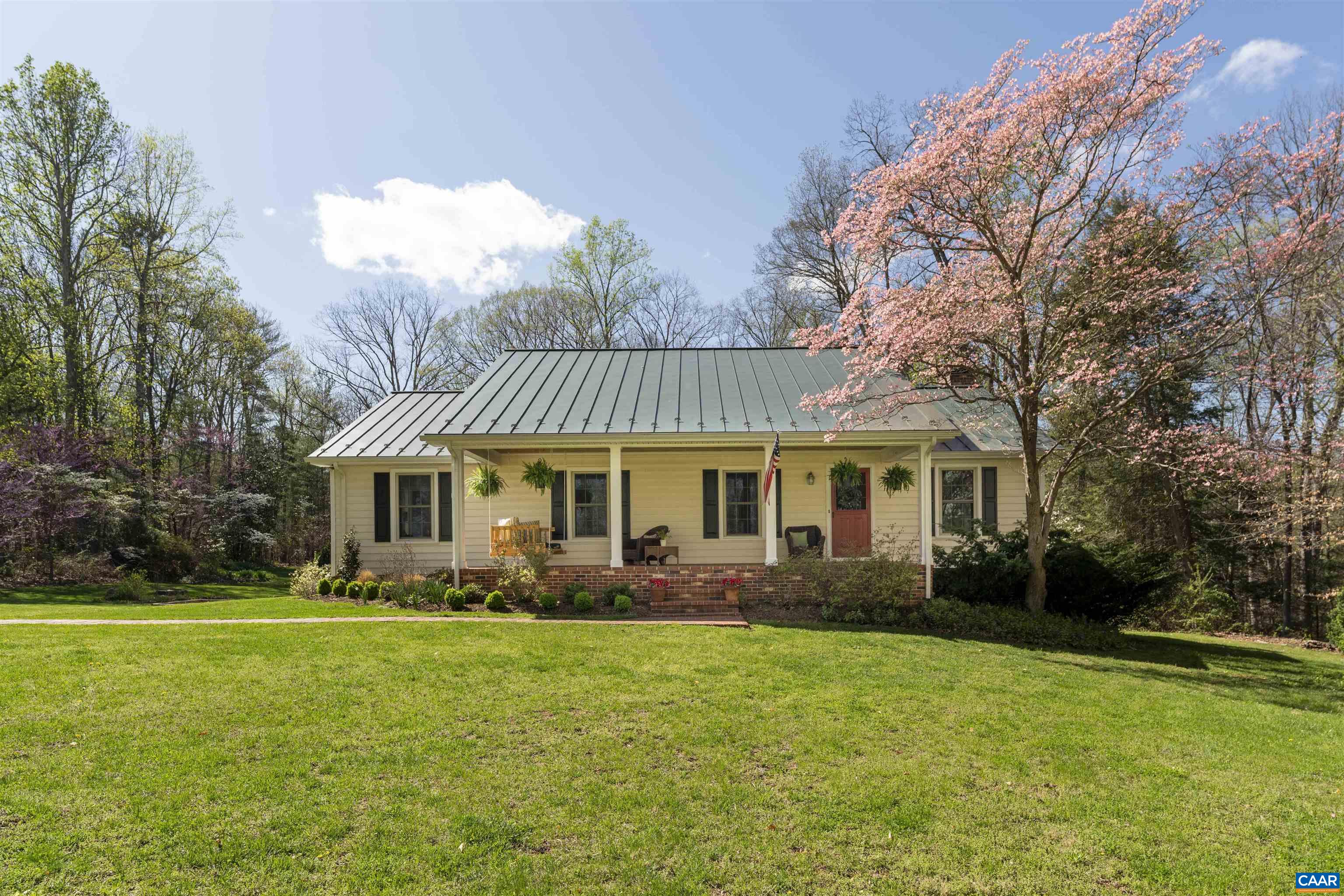 Meticulously maintained, beautifully landscaped country retreat in a serene setting with seasonal mountain views in the Ivy Elementary district! This exquisite property offers so much within its 5 acres. The home has been lovingly updated over the last five years with extensive updates including new metal roofing on all three structures, refinished hardwoods, kitchen updates, new lighting, finished basement spaces, a new basement bathroom, fresh interior painting, and so much more. Designed to offer comfort both inside and out, there are ample spaces for gathering. Inside enjoy the open concept kitchen/living/dining space with the large wood burning fireplace, take the party to the huge back deck for a BBQ, finish the night at the custom firepit or in the basement shooting pool next to the wood stove. The current owner has taken exceptional care of the property adding extensive stone walls, raised garden beds, invisible fencing for pets, recently repainting the exterior and trim, the list goes on. A detached 2 car garage provides additional storage, a rear workshop with electricity also features an attached coop so bring your chickens! Privacy and comfort just twenty minutes from Charlottesville.