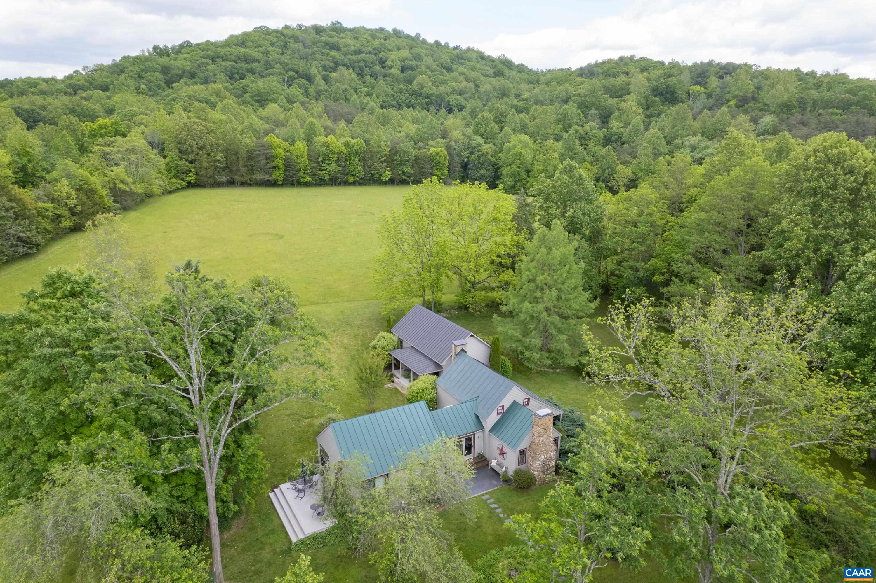 Carefully preserved and updated for comfort, this rare C. 1820 chestnut log cabin is move-in ready for full-time country living or weekend gatherings.  Nestled in the midst of 85 exquisitely private acres in Western Albemarle, the property offers several additional home site options.  The original living room with stone fireplace is the heart of the home. A bright kitchen addition features custom English style cabinets with hand cut stenciling, butcher block counter tops, stainless steel appliances, two generous pantries, an island and slate and pine floors.  Sliding doors open to a wide deck with room for entertaining. A second addition, completed in 2008, leads down a bright, tiled hallway to the primary suite which boasts a vaulted ceiling, cedar closet and red oak window trim and flooring. The entire tract features Blue Ridge views, stocked pond, woodland trails, rolling pastures, streams and vivid night skies.  Harris Mountain Farm is located just 15 mi from Charlottesville and the University of Virginia, 10 mi from the Charlottesville Albemarle airport,  5 mi from a 600 acre county park, and 18 mi from Shenandoah National Park.  The farm is also a short drive from numerous wineries, ski resorts, breweries and orchards.