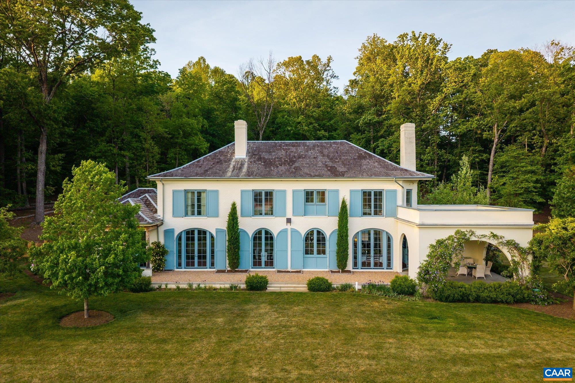 Set on 21 private acres in Blandemar Farm Estates, Sunday Lilac is a French Provincial estate of enduring style and substance. Designed by Peter Block Architects and completed by Young & Meathe Homes in 2021, the home is perfectly positioned to capture uncomparable mountain views and is surrounded by mature landscaping, curated gardens, and natural beauty.  Inside, classical architecture meets refined finishes, including reclaimed French oak floors with hand-laid parquet and hand-painted Gracie wallpaper in the entry. The kitchen pairs marble surfaces, Delft tile, a Lacanche range, Sub-Zero refrigeration, and a full butler’s pantry for seamless entertaining. Fixtures by Perrin & Rowe and RH, along with lighting from Paul Ferrante, Jamb, and Murano Glass, add character and continuity throughout.  Five bedrooms and 5.5 baths include a serene primary suite with heated marble bathroom floors and Osborne & Little wall coverings. Two wood-burning fireplaces with Italian stone surrounds serve as elegant focal points and add warmth and atmosphere throughout the home.  Just minutes from Charlottesville, Sunday Lilac offers a rare opportunity to enjoy elegant, design-forward living in one of Albemarle County’s most distinguished communities