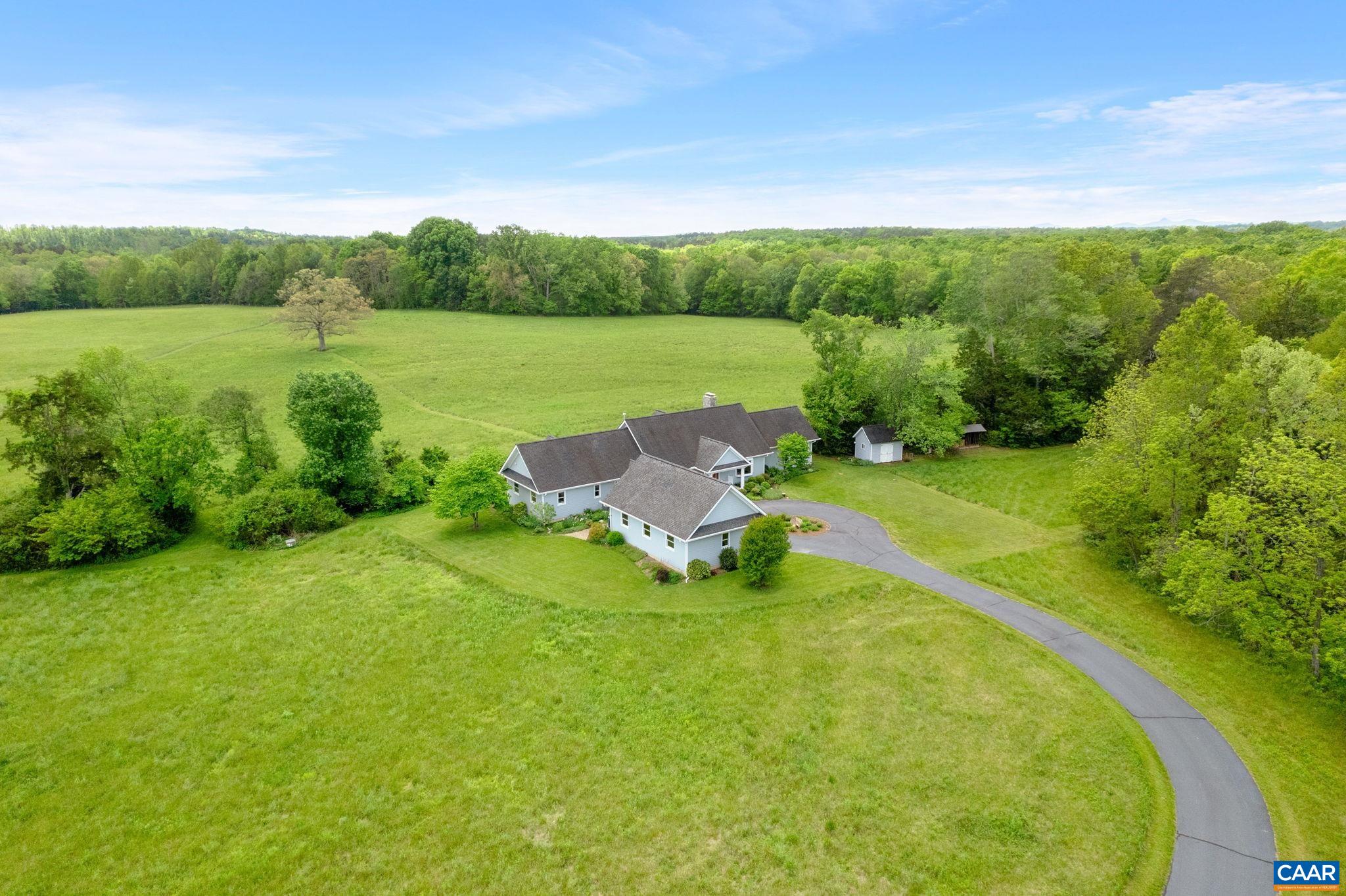 OPEN HOUSE SATURDAY, JULY 12 ** Great Oak Farm is a beautifully designed custom home on 62+ acres of open meadow and woods just south of Keene in the Totier Creek watershed. A paved driveway meanders through a pasture teeming with wildlife. Built in 2002 by builder Karl Hrebik, the entryway leads to a handsome great room with vaulted ceilings, a soaring stone fireplace, and doors that open out to a towering oak tree for which the property is named. Heart pine and white oak floors in main living areas. The large kitchen, with its quartz counters and a generously sized island with built-in wine storage and vegetable sink, is great for entertaining. Enjoy easy access to the large Trex deck from the sunroom, living areas, and owner's suite. The private owners' suite includes a large walk-in closet as well as french doors leading to a patio overlooking the back field. Downstairs, the partially finished basement is large enough for movie parties and billiards. Storage space galore in the basement utility area. Outside, the breezeway connects to a 2-car garage with an adjacent hobby room. The garden shed and tractor shed provide extra storage space. Fiber internet! Great Oak Farm is a nature lover's retreat, 20 min. to Charlottesville.
