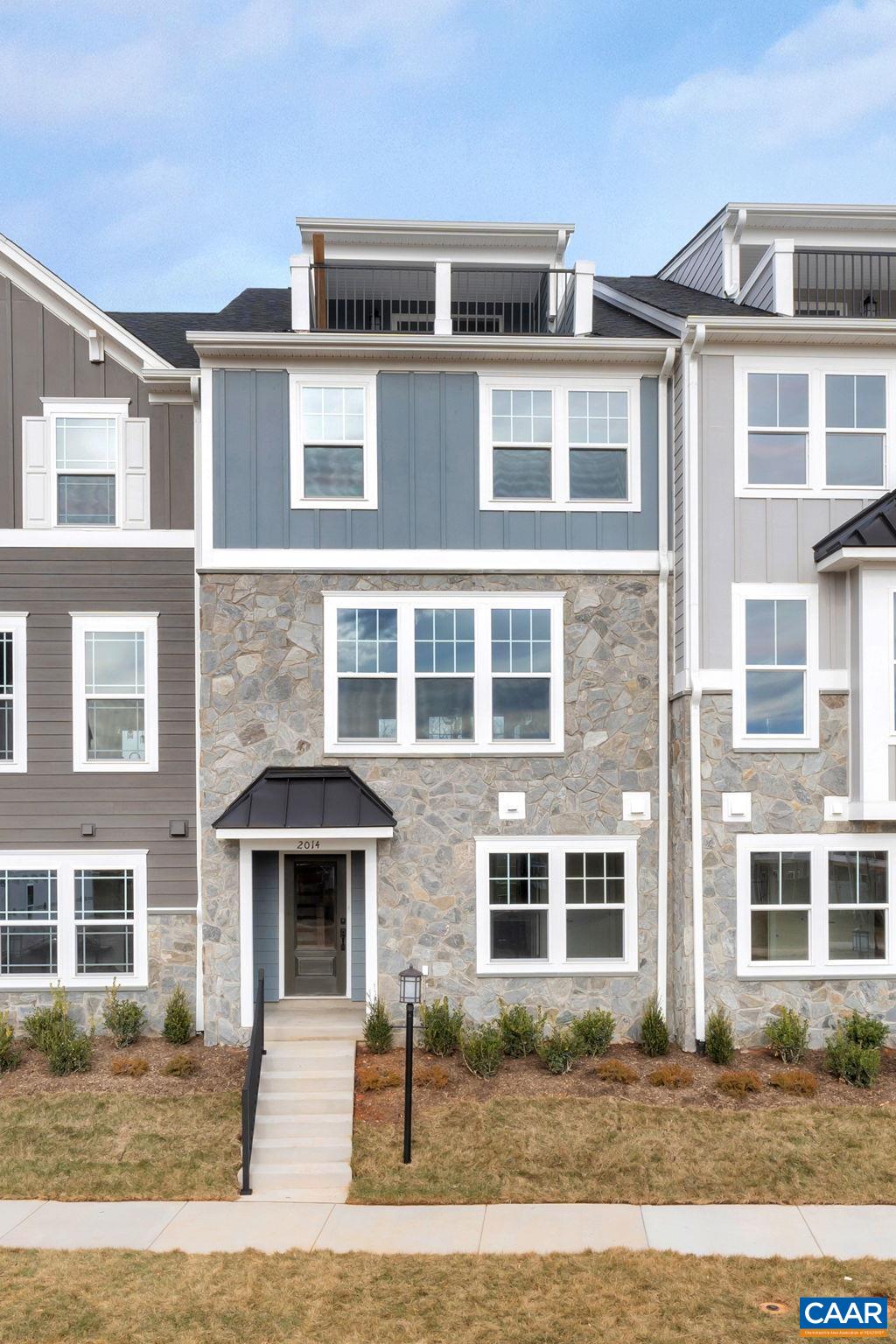 Under construction for an August 2025 move-in, the Poplar II townhome is located in Glenbrook, where scenic Blue Ridge Mountain views meet neighborhood parks and trails. This interior unit offers farmhouse-style architecture with stone accents and a modern floor plan across four levels. The main living area highlights a spacious kitchen with a walk-in pantry, plus an elevated rear deck just off the dining area. A first-floor bedroom with an adjacent full bath provides a flexible space for guests or work-from-home needs. Upstairs, three additional bedrooms include a comfortable primary suite, and the top floor features a loft and rooftop terrace with mountain views. Additional features include a two-car attached garage, oak stairs, wood shelving, upgraded trim, solid core doors, and an energy-efficient furnace. Walkable to Crozet Park and planned direct access to downtown Crozet. Photos represent a similar home; some finishes may vary.