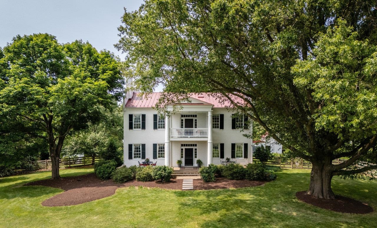 Rich heritage and diverse future potential combine at Bogota, a circa-1845 Greek-Revival manor on 52 acres with a quarter mile of frontage on the Shenandoah River! The main house has soaring 10-11' ceilings, rich millwork, & wood flooring throughout. Enter through an 11'-wide central foyer into stately living spaces: 17×32 living room with piano doors, 16×16 parlor, 11×16 study, 15x20 dining room--with original features such as 8" baseboards, chair rail, crown moulding, & built-ins. 16x17 kitchen with Sub-Zero fridge & gas cooktop. Upstairs are 5 bedrooms and 3 full baths including owner's suite with 15x20 bedroom, large walk-in closet, & fully tiled shower. This home boasts a remarkable 7 wood-burning fireplaces. Outdoor spaces also abound with 5 different porches! Multiple outbuildings, including large bank barn with 4 stalls & tack room, former summer kitchen and smokehouse. Riding ring and two paddocks with loafing sheds. 2nd dwelling on the property, "The 1756 House," adds 1,600+ sq. ft. of living space, 2 bedrooms & full bath. Surrounded by land under conservation easements, Bogota offers protected, uncompromised mountain views. Make it your equestrian estate, income producer (event venue, B&B), or private retreat!