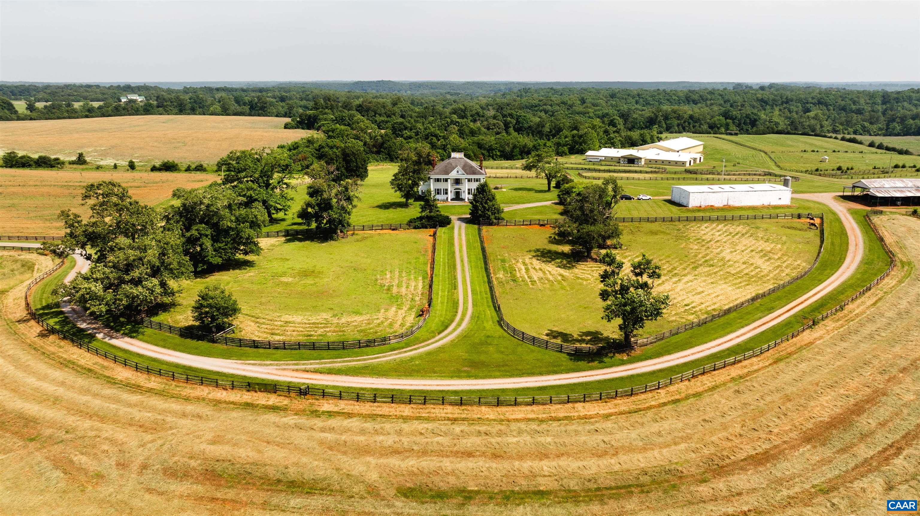 Greenfields Farm spans 753 acres just outside historic Scottsville, VA. A rare blend of rolling pasture, mature timber, and rich history, the property features a 1904 Colonial Revival main house with original architectural detail, a grand spiral staircase, arched transoms, and sweeping views from the widow’s walk. The residence offers copious amounts of living space, with three separate apartments and a caretaker’s home providing options for guests, staff, or extended family. Formerly a working horse farm, Greenfields includes fenced paddocks, a spring-fed creek, a stocked pond, a lake, and five wells. Equestrian facilities include a stable with 48 stalls, an indoor arena, a tack room, foaling stalls, grooming bays, hay storage, offices, and wash bays. Additional improvements include two equipment barns, grain silo, dog kennels, riding trails, and four gated entrances. With ties to Governor Wilson Cary Nichols and Lady Astor, Greenfields is a legacy estate of rare scale and beauty.