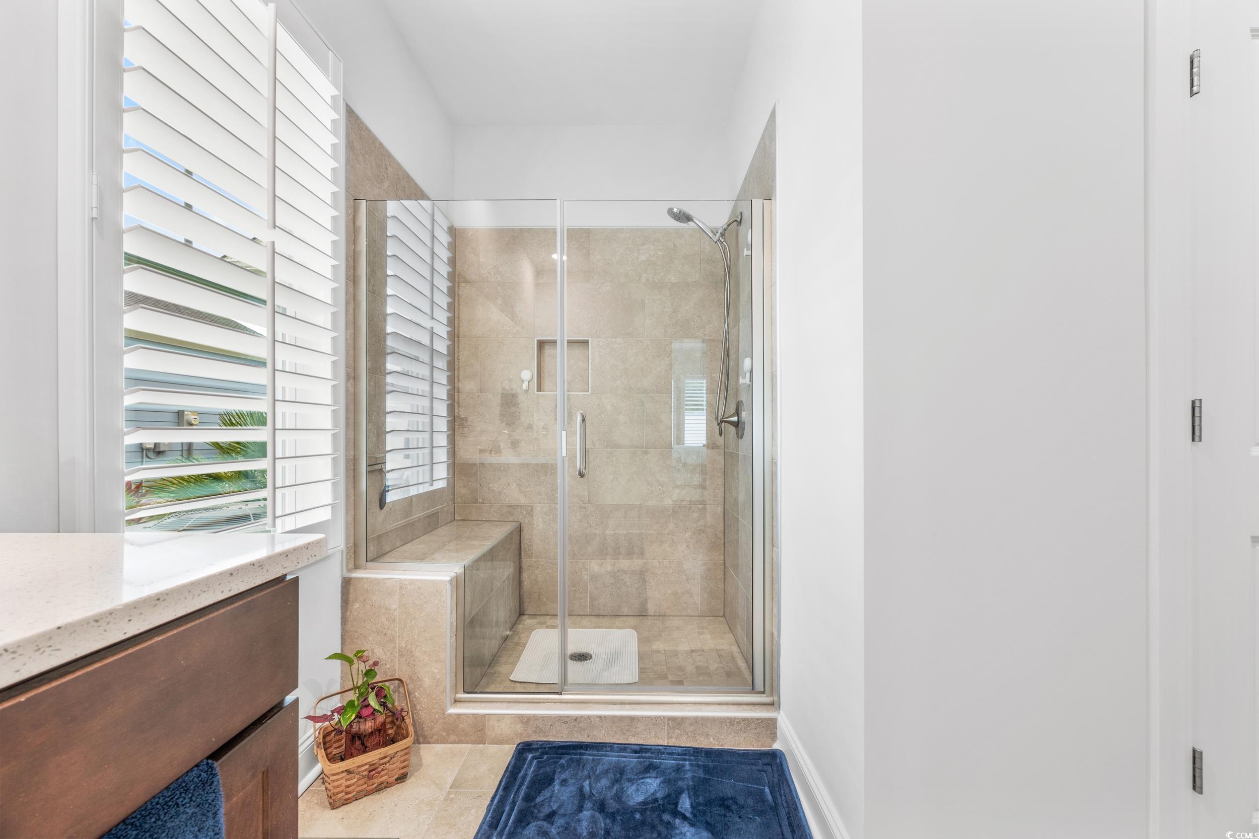 Bathroom with vanity, tile patterned floors, walk in shower, and plenty of natural light