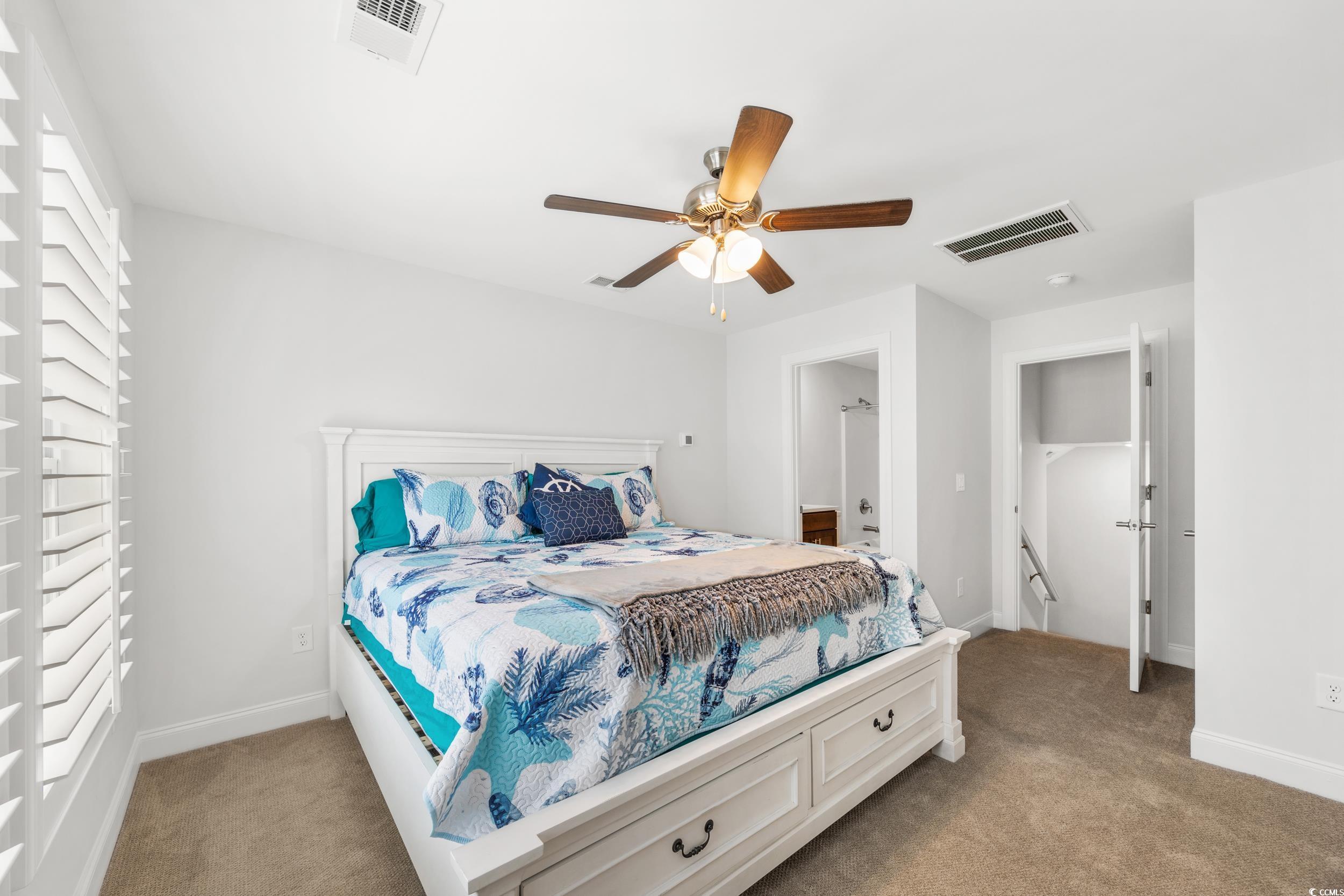 Bedroom with light colored carpet and ceiling fan