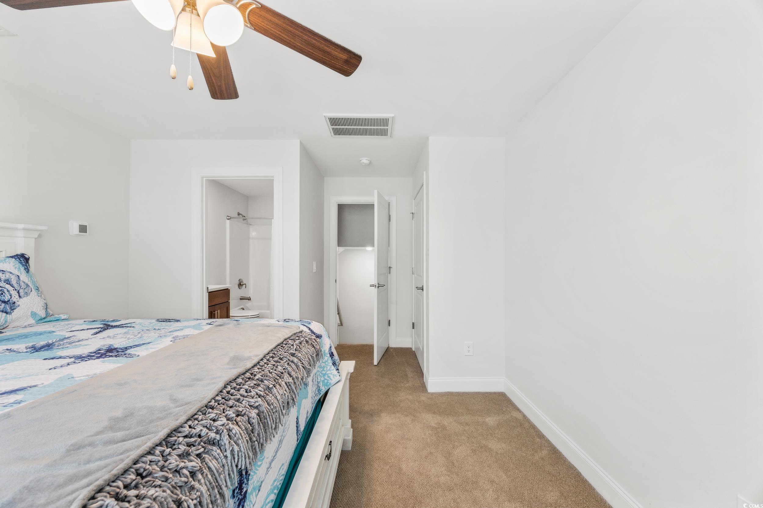 Carpeted bedroom featuring ceiling fan
