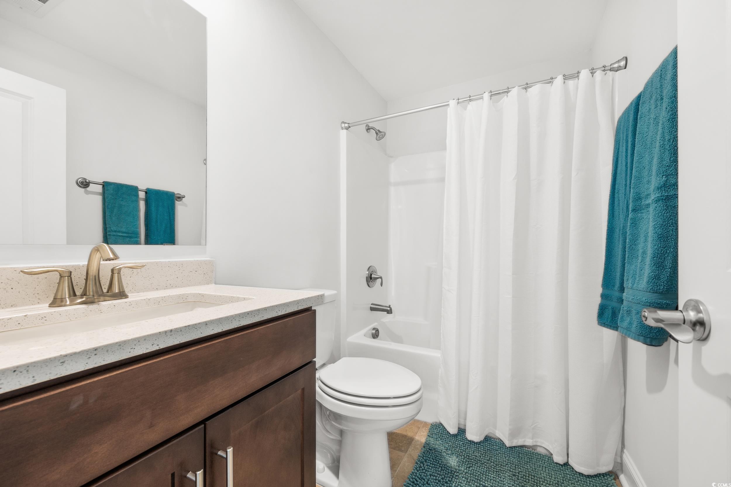 Full bathroom with toilet, shower / bath combo, vanity, and tile patterned flooring