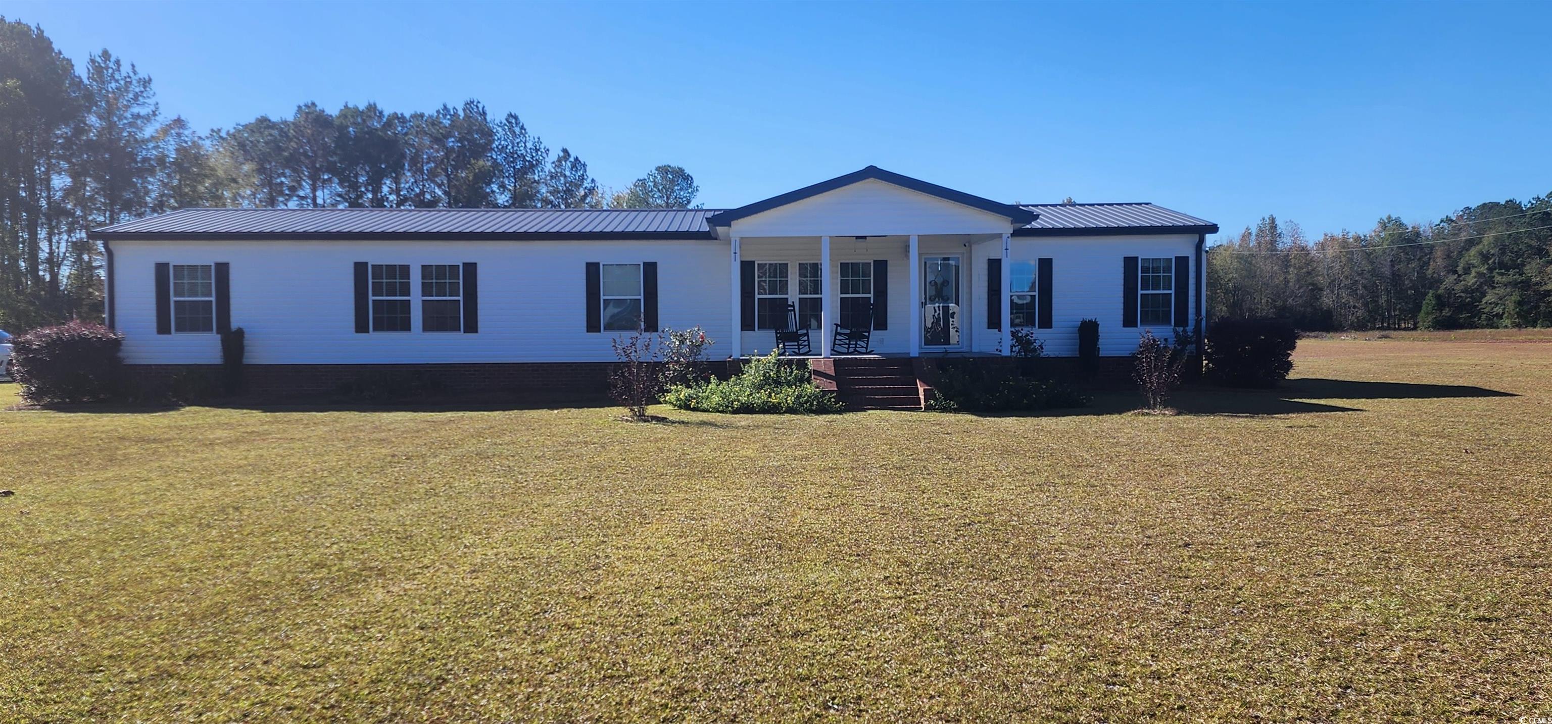 Welcome to this beautiful recently renovated ScotBuilt home at the heart of comfort and convenience! Nestled in a peaceful Florence County community just minutes away from Florence or Lake City. This charming residence offers a perfect blend of modern design and country living. Drive up the long gravel road and park underneath the spacious carport with 3 bays. Step inside to an open concept living space, with newly installed LVP and carpeted bedrooms. The spacious kitchen boasts contemporary appliances and ample granite counter space with tile backsplash. A large formal dining room is conveniently located adjacent to the kitchen. Retreat to the master suite, featuring a large sized bedroom with a large walk-in closet and a well-appointed ensuite bathroom featuring granite countertops, tile shower, and a free-standing tub with Delta faucets. Enjoy never-ending hot showers and baths with the Rinnai tankless hot water heater. Cozy up in the den on those cold nights with the warmth of a ventless gas log fireplace. Three additional bedrooms and a second bathroom with double sinks with granite countertops and a separate bath area provide comfortable accommodations for family or guest. Settled on a nice 5-acre lot with a welcoming front porch, this home offers the ideal space for outdoor gatherings with plenty of room. Relax by the above ground pool on a 22x15 sun deck. Outside sits a large fenced in gravel area with a large metal enclosed building with central heat/AC, an upstairs storage area and plumbing for a complete bathroom. The outside building has 5 roll ups doors to conveniently store all your toys. Located outside the fenced in building is a 50x50 red iron shed that is wired for RV/Camper storage. At the back of the property there is a wired 12x 24 dog pen with a concrete pad, water access and a metal roof. Feel safe and secure at home with the professionally monitored home security system with advanced motion sensors and door alarms. Don't miss the opportunity to make this beautiful house your home!