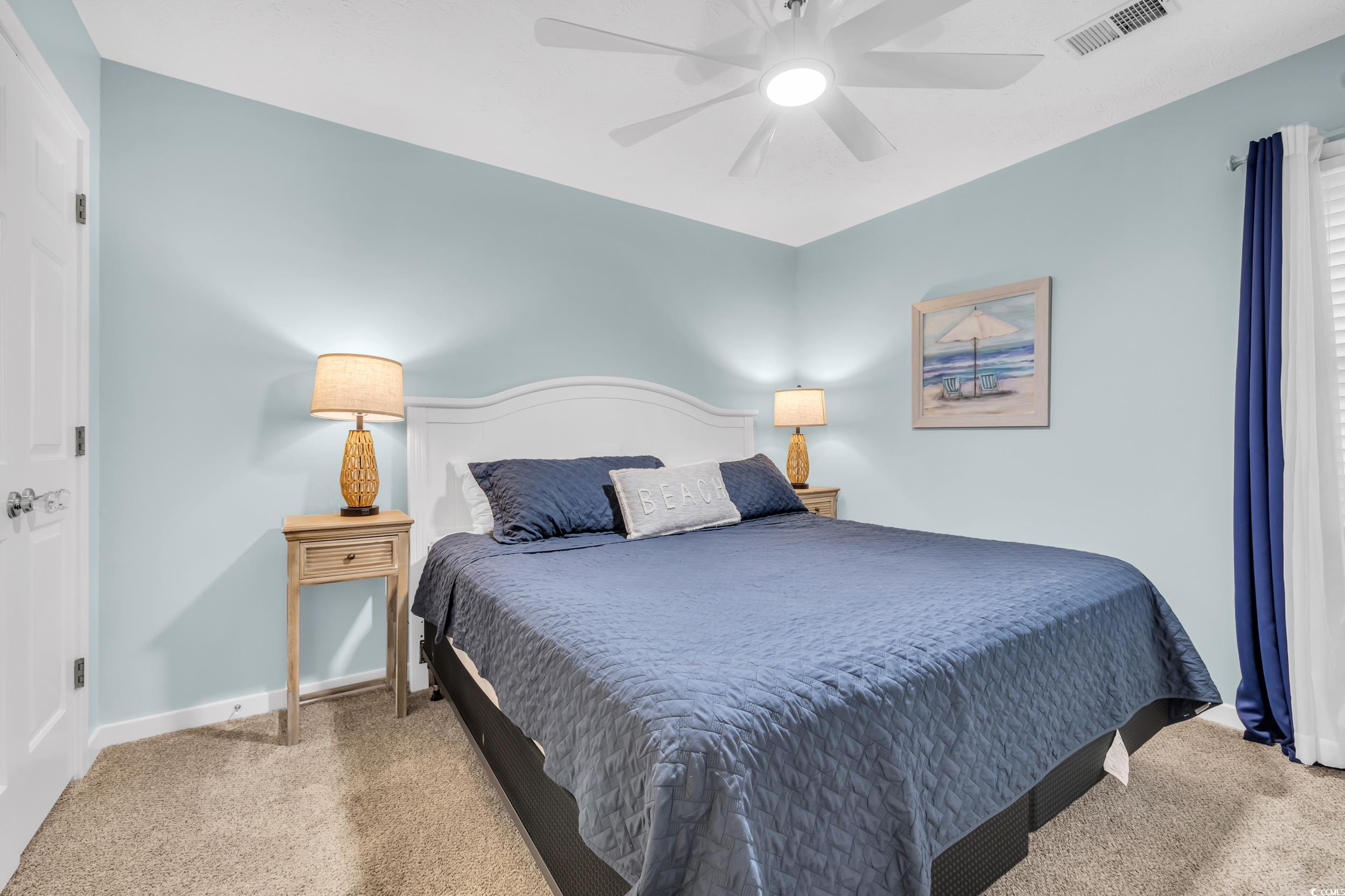 Carpeted bedroom with ceiling fan