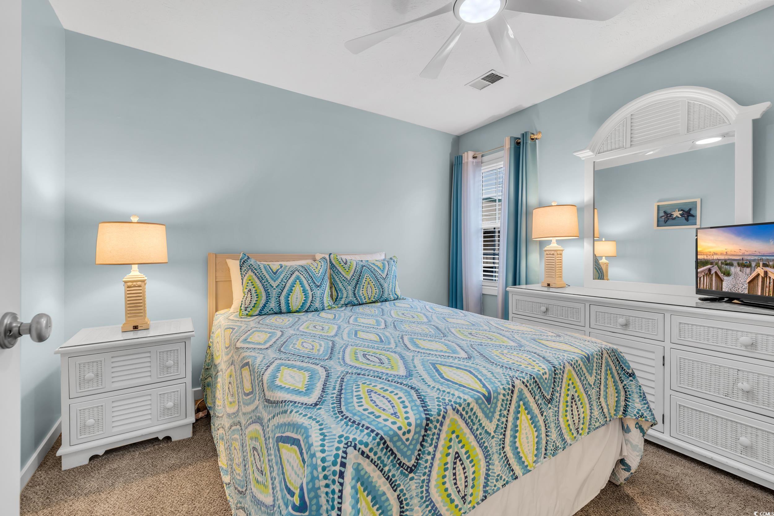 Carpeted bedroom featuring ceiling fan