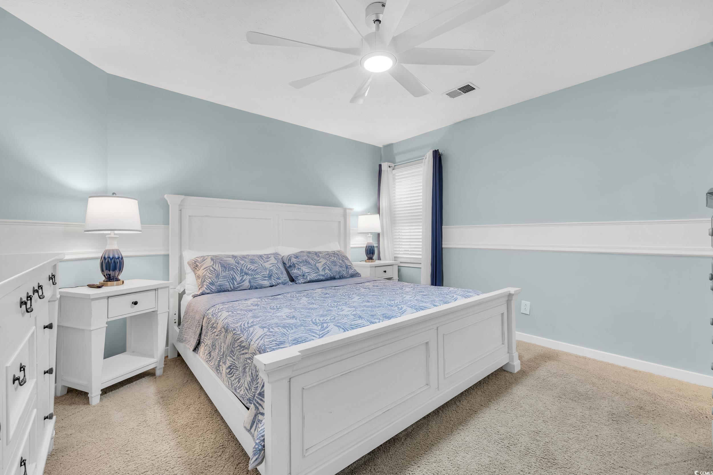 Bedroom with light colored carpet and ceiling fan