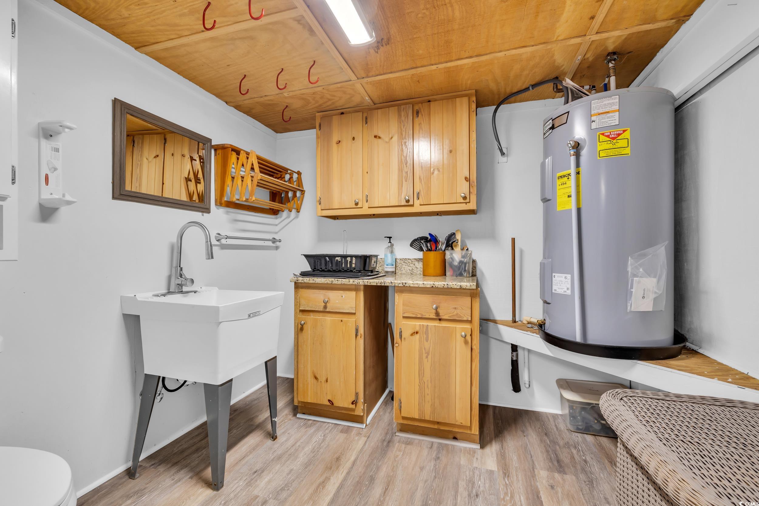 Kitchen with electric water heater, wood ceiling, and light wood-type flooring