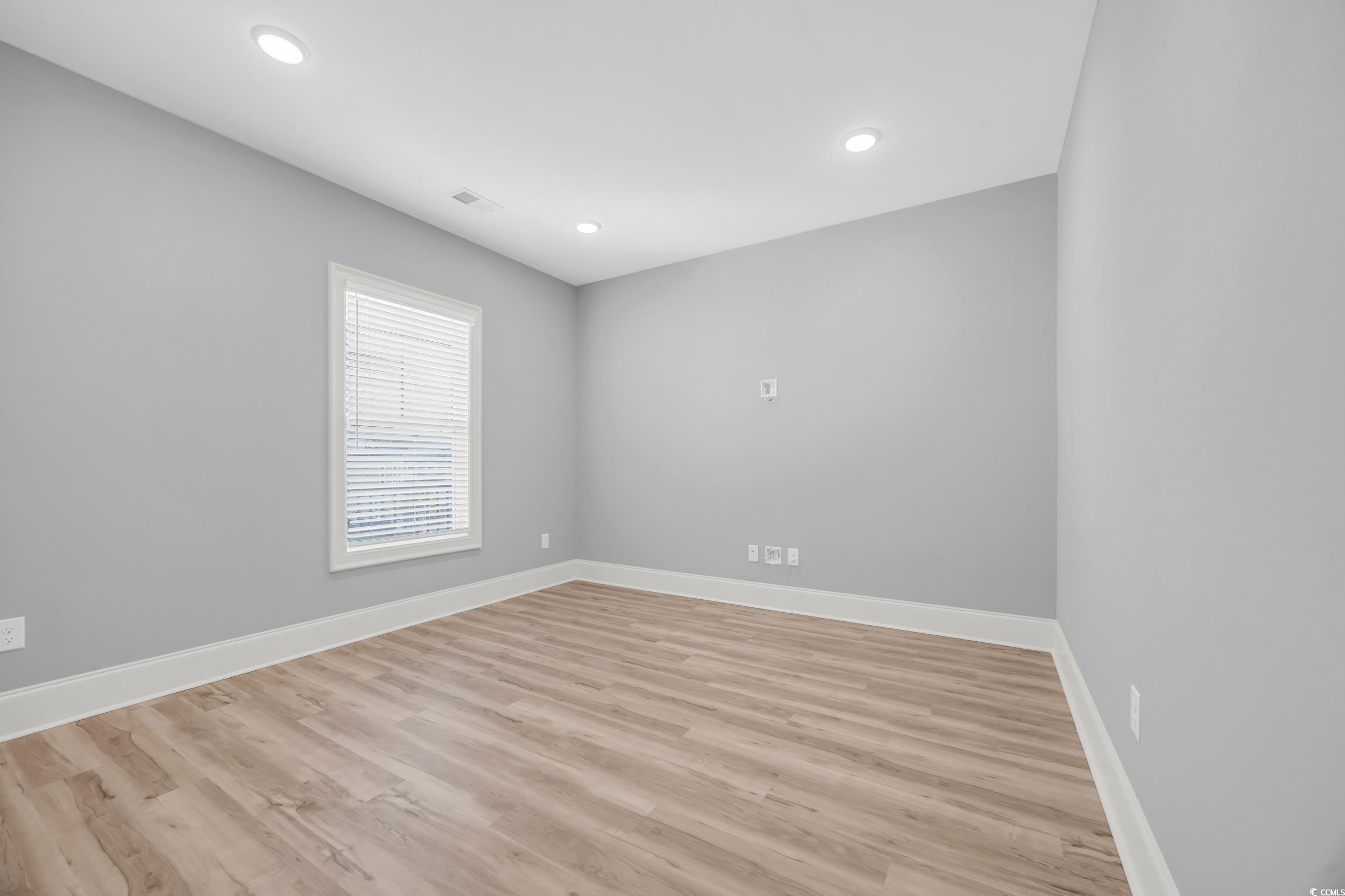 Unfurnished room with baseboards, light wood-type flooring, and recessed lighting
