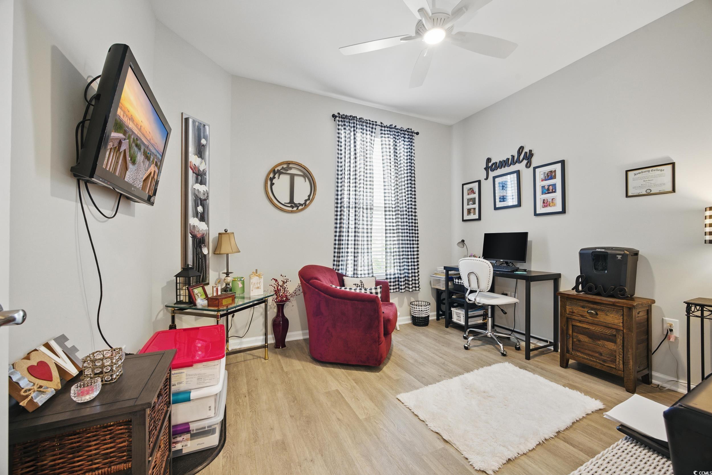 Office space featuring light wood-style flooring, ceiling fan, and baseboards