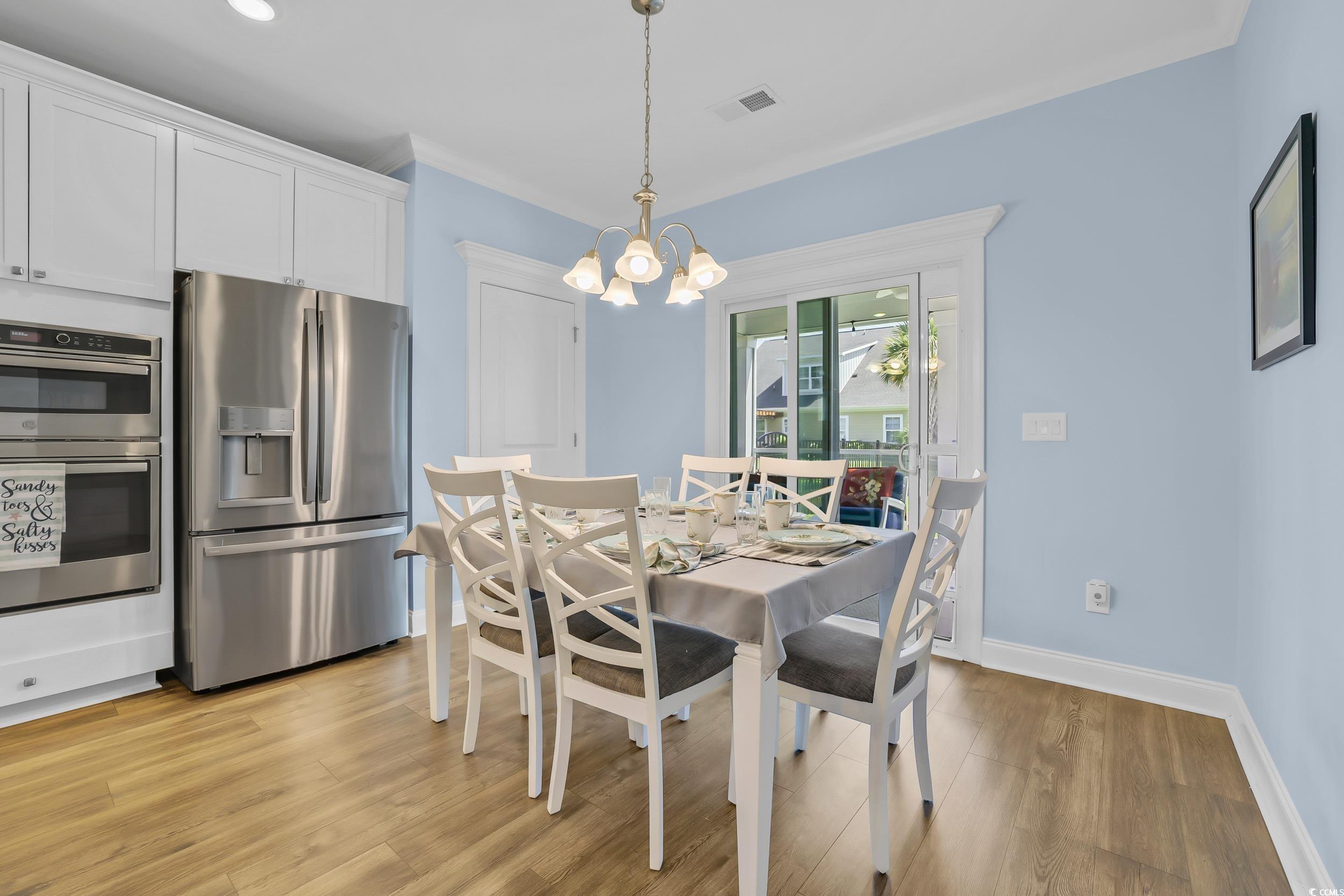 Dining space featuring a chandelier, light wood-style floors, and baseboards