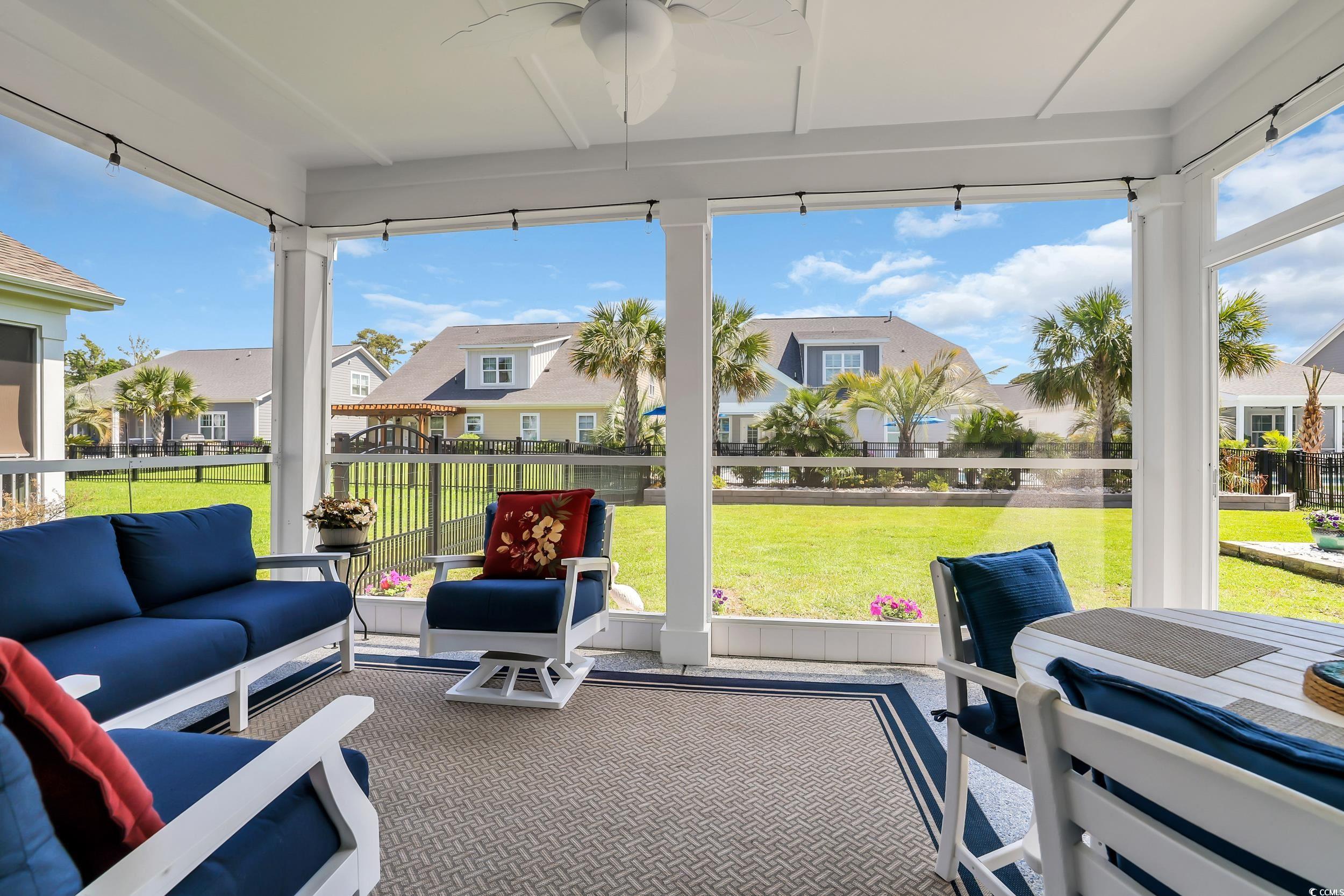 Sunroom with a residential view, a ceiling fan, and an outdoor hangout area