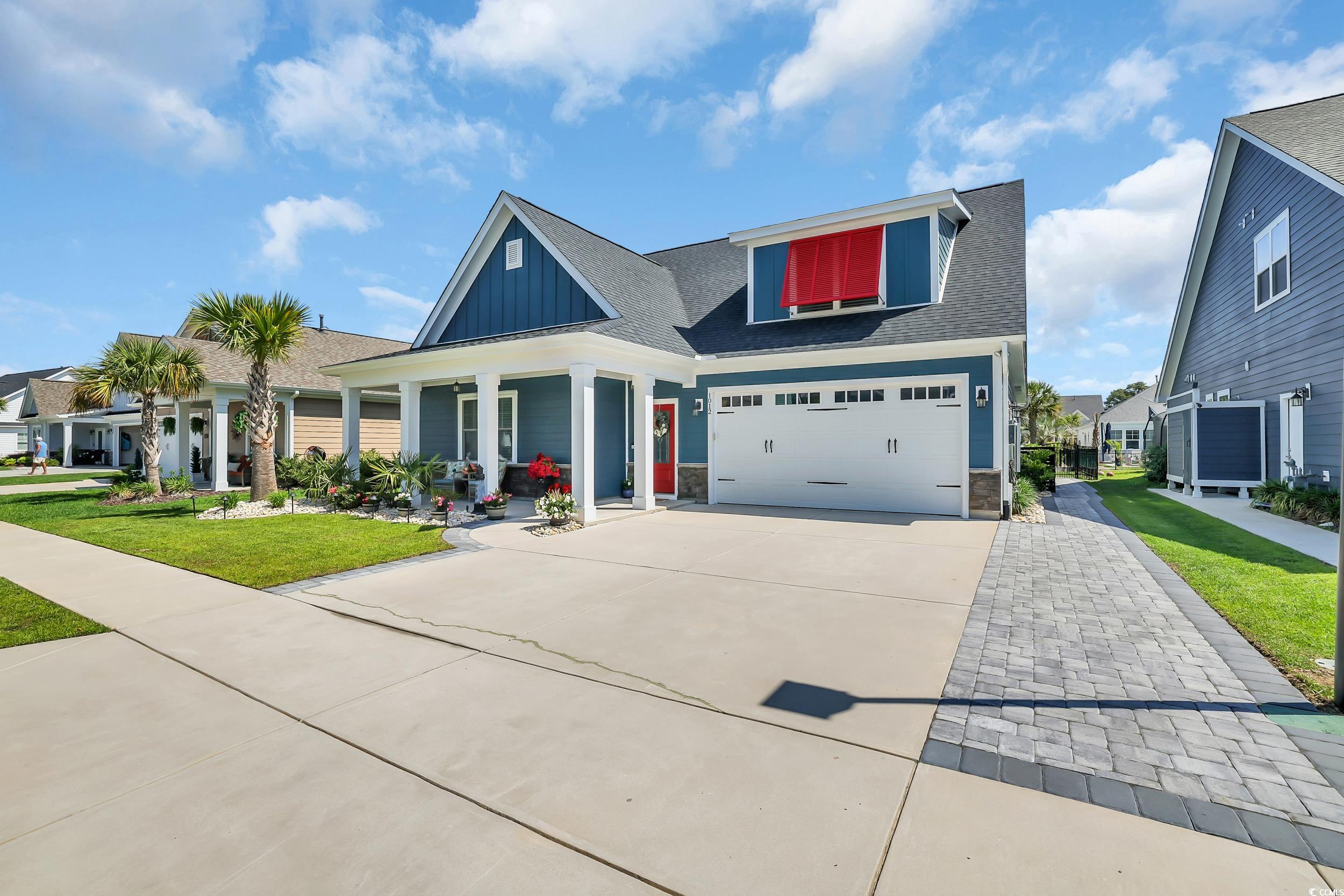 View of front of house with driveway, board and batten siding, a front yard, an attached garage, and a shingled roof