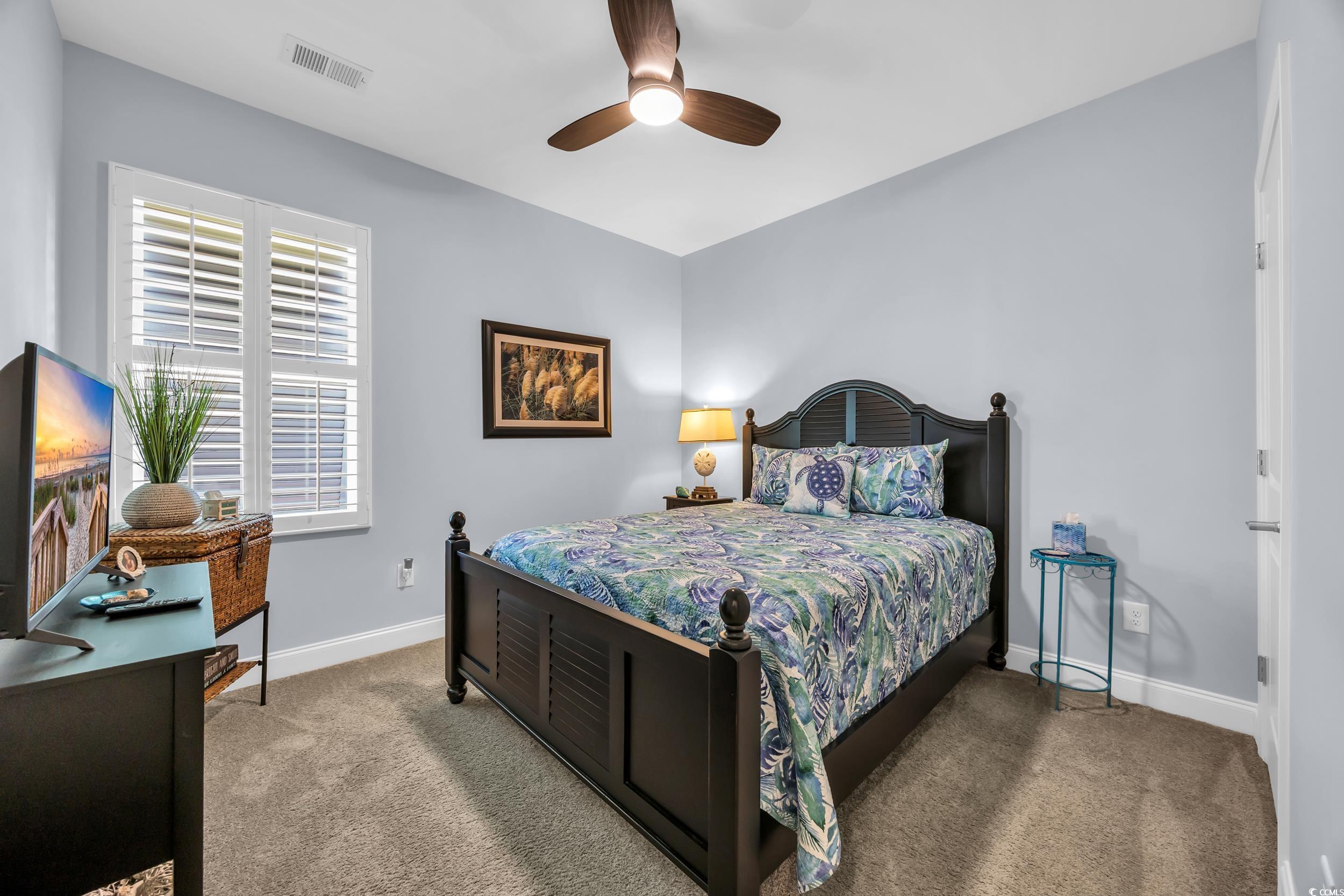Carpeted bedroom featuring baseboards and ceiling fan