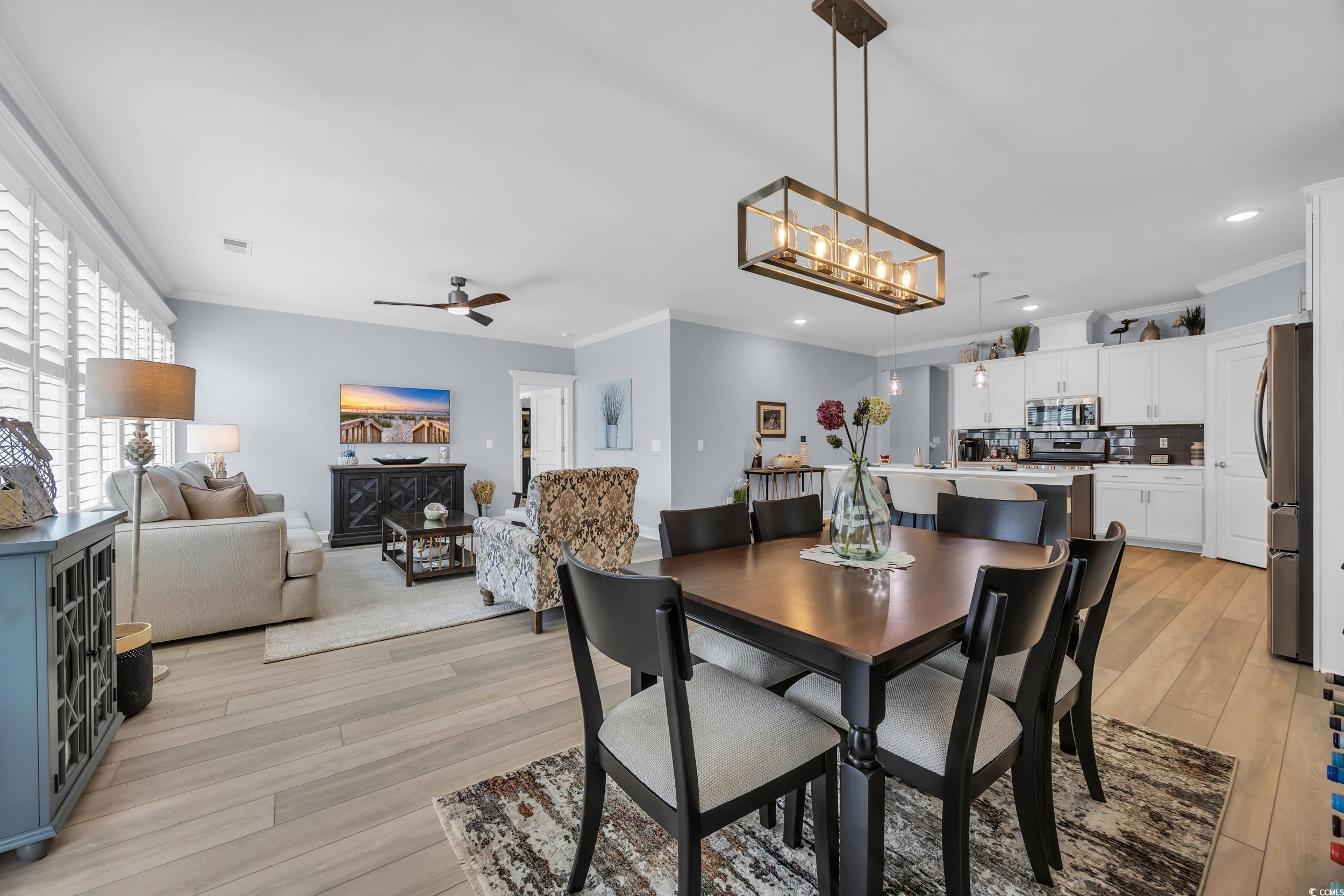 Dining area with ornamental molding, light wood-style flooring, ceiling fan, and recessed lighting