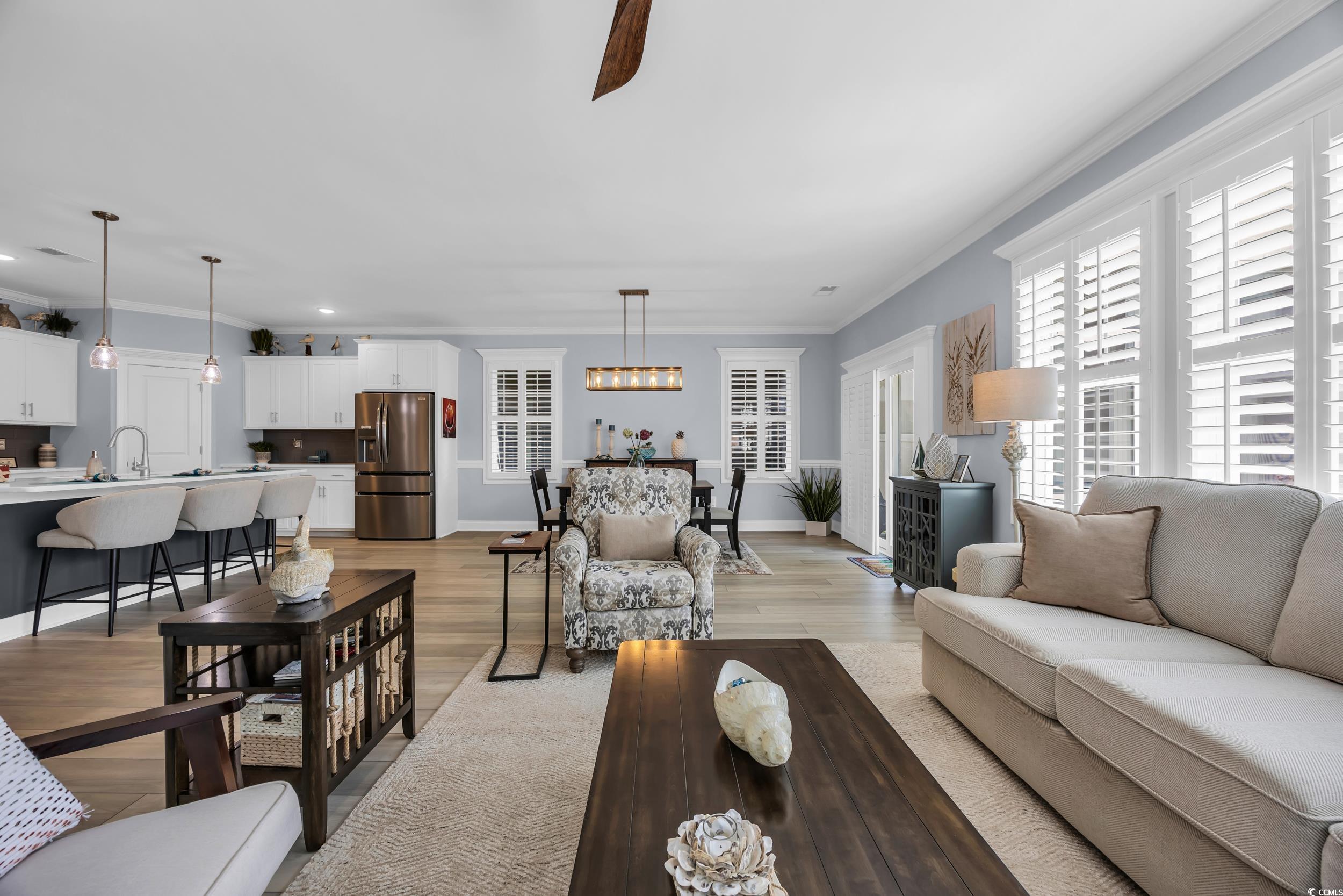 Living area featuring ornamental molding, recessed lighting, light wood-type flooring, a chandelier, and baseboards