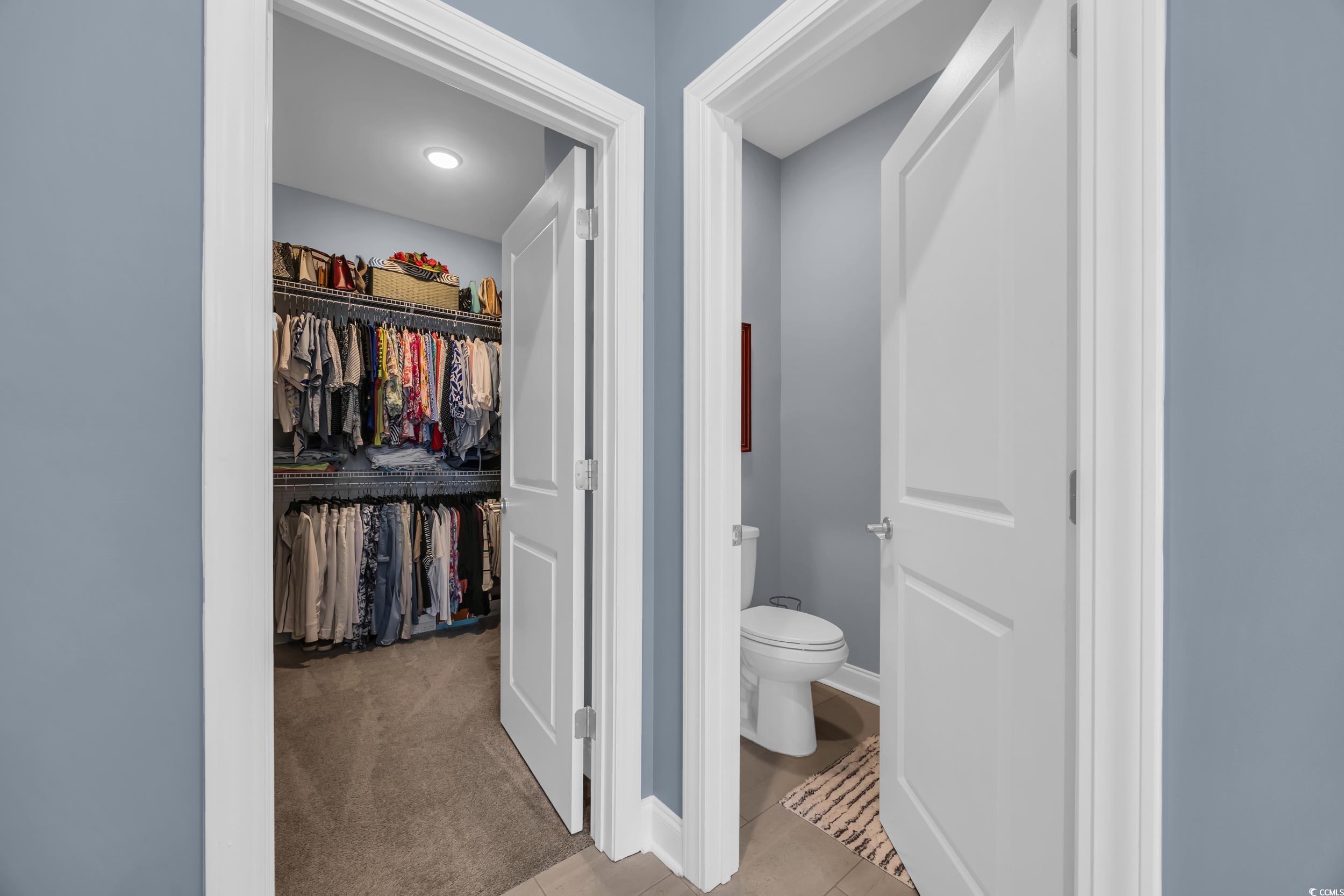Corridor featuring tile patterned floors and carpet flooring