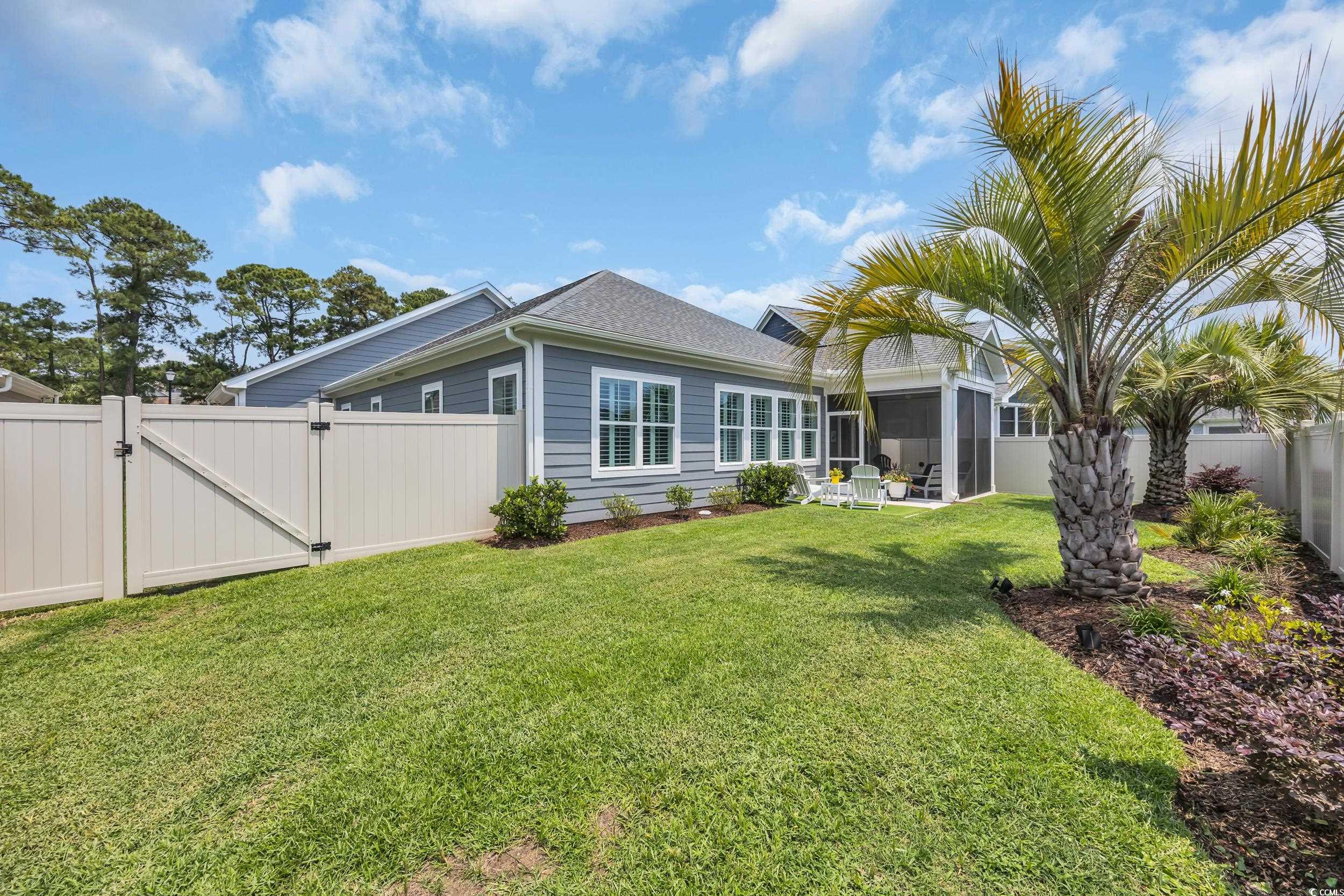 Back of house with a gate and a sunroom