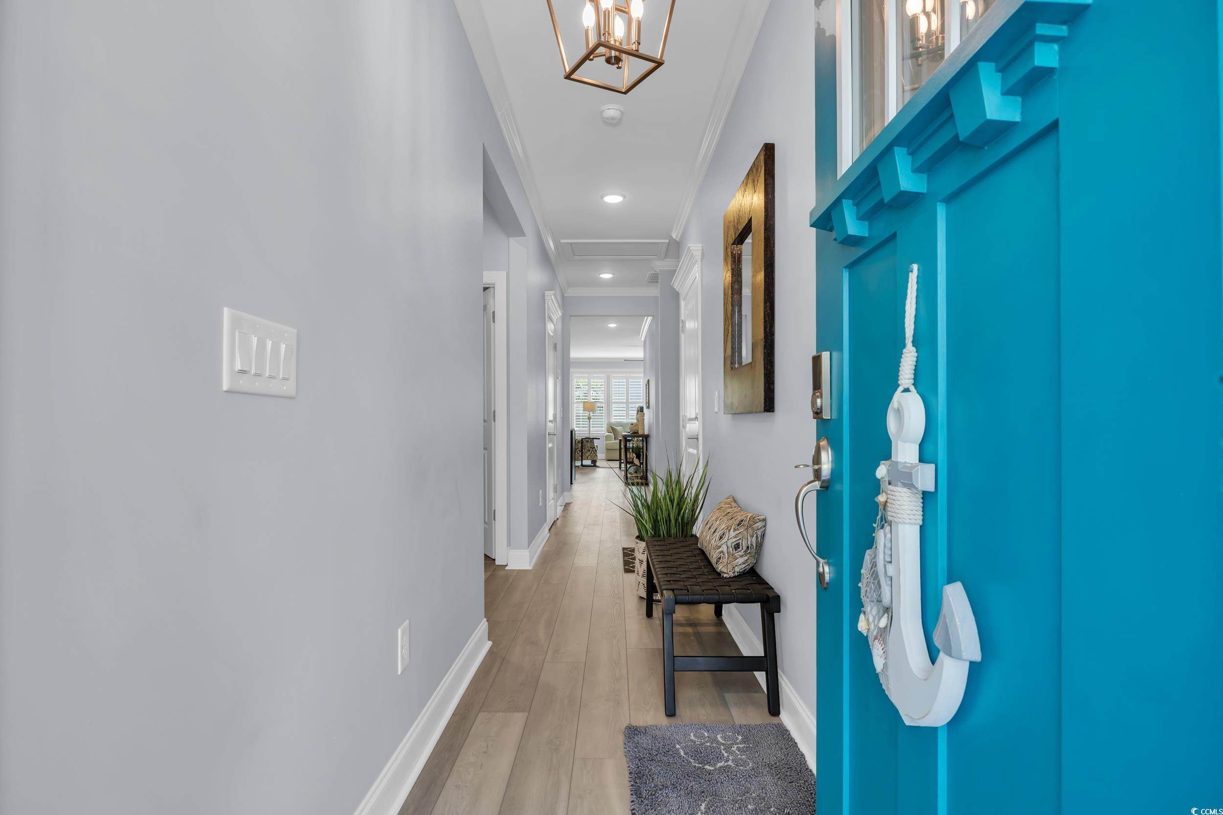 Hall featuring baseboards, crown molding, light wood finished floors, a chandelier, and recessed lighting