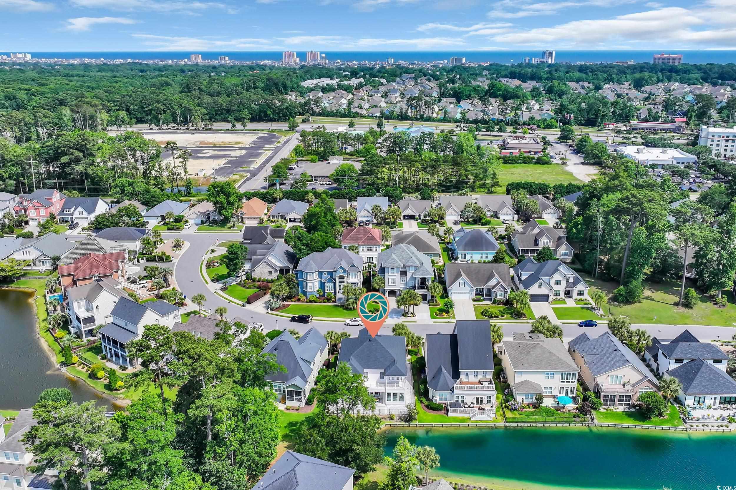 Aerial perspective of suburban area featuring a nearby body of water