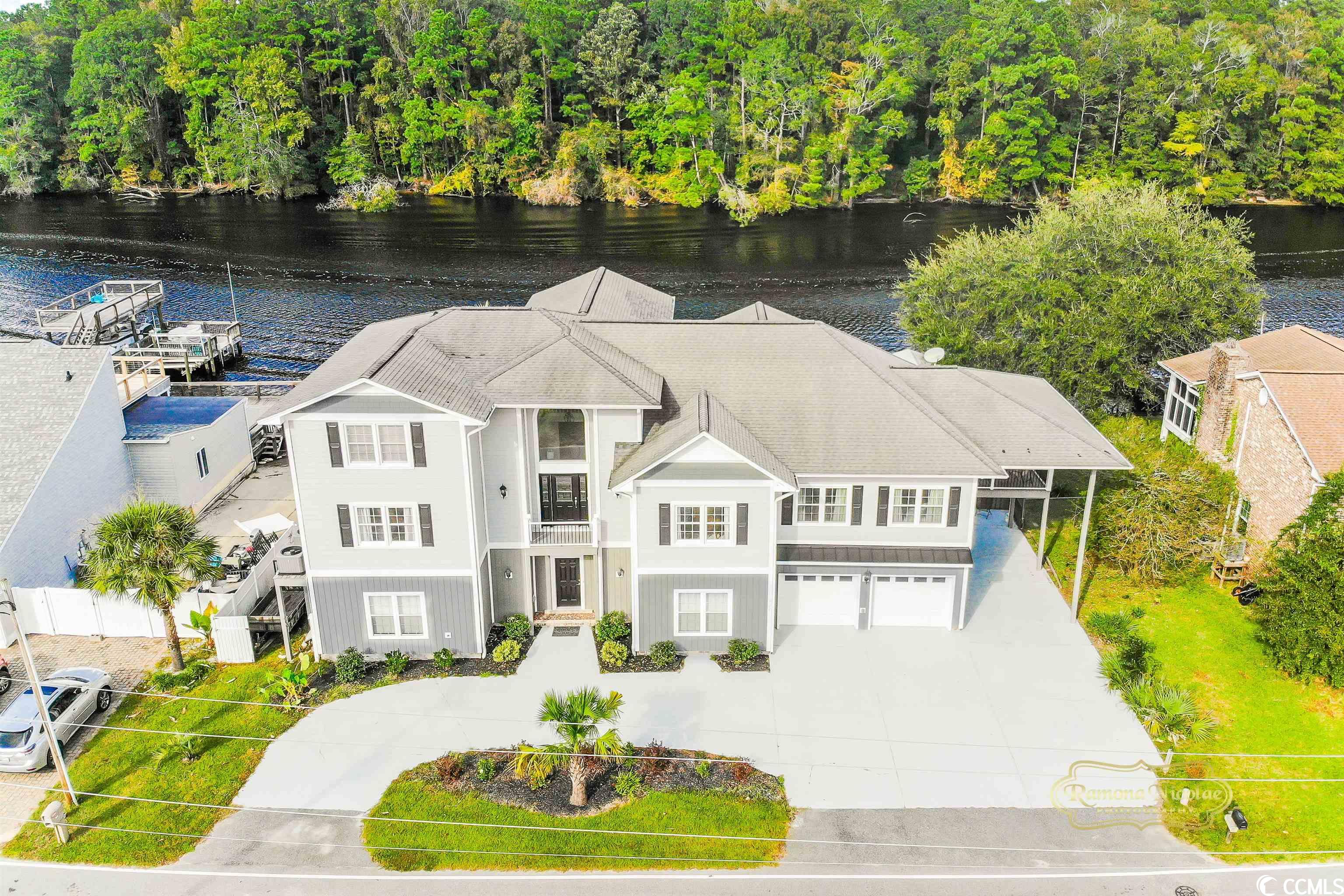 what an extraordinary home ! - direct on the intracoastal waterway.! expansive living areas & amenities!  you can make this your lifestyle home.! with all the waterway views & watching the boats go by!! plenty of activity in warm months & traveling boats in spring & fall !   approximately 4000 sq.ft.heated living space with 16x26 outside deck overlooking waterway!- just outside your kitchen and den!! steps from deck take you to back yard & also your own private boat lift with shed cover - & jetski lift for your toys! just head out to your boat or jet ski & hop on the water! this home has been extensively renovated with all modern updates! home has large den with 18ft ceilings - & ventless gas fireplace! eye-catching natural stone wall above fireplace! & waterway views.! upgraded luxury vinyl plank flooring throughout main living level & carpet &tile on second floor. spacious kitchen with breakfast nook overlooking waterway, granite counters( lots of counter space), custom cabinets - 42” upper cabinets, upgraded stainless appliances, under-cabinet lighting, 3ft x 6ft center island w/ cooktop!  plenty of storage space in kitchen - including walk-in pantry with plenty of shelving! formal dining room. all living areas flow into each other!!  on mainlevel there are 2 master suites - each of these suites has lots of closet space & the bedrooms have roomy measurements!!  the primary master suite has approximately 700sf & views of the water! 2 walk-in closets here w/ plenty of shelving & hanging space ! this master bath has double vanity, tiled walk-in shower, whirlpool tub & glass block window! the 2nd bedroom suite is extra large as well w/ bath & linen closet !also on this floor is an in-law suite/guest suite with private bath & kitchenette & separate entrance!! there’s even your own private deck( 13x14 )overlooking the waterway! on 2nd floor living level there are 2 additional large bedrooms w/ large jack & jill bath connecting these 2 rooms! also there is walk-thru connecting closet between rooms & extra closet in each bedroom. waterway views from one br ! access these bedrooms from staircase in open space w/18ft ceiling or your interior elevator (measures 3.5x4). elevator goes from ground level to both living area levels! on 2nd floor living level is the 1st multi-usespace - game room/office/exercise room/craft room-your choice! this area has 3 walk-in attic storage areas! vinyl plank flooring in this room! connects to the 2 bedrooms on this floor by bridge in area that overlooks den!  rounding out the first floor living level is laundry room w/custom cabinets/granite & built in platform for front load w/d! utility sink & plenty of room here for doing laundry w/ water view! next to laundry room is 1/2 bath & elevator! you access the guest/inlaw suite directly from elevator using private lock-out door to suite door! ground level is approximately 2300sf - unfinished space but heated & cooled!! this space can be multi-use as well. exercise area, craft area, man cave, extra-huge storage area! there’s an extra w/d hookup if you want to do laundry here for outside/cleaning items! a 1/2 bath is here/conveniently located  for downstairs area. you can park in your attached 2car garage - bring in purchases & take elevator up to 2nd & 3rd levels! outside there is ample parking with additional carport & driveway.  head out to water for dock directly on water-enjoy sitting here to watch activities on water or the beautiful sunsets on the waterway!!  located only minutes to market common area & a few miles to the beach ! what an opportunity for your primary, 2nd home or as a shared retreat !  measures & info approximate-buyer responsible to verify. sellers are licensed sc agents.