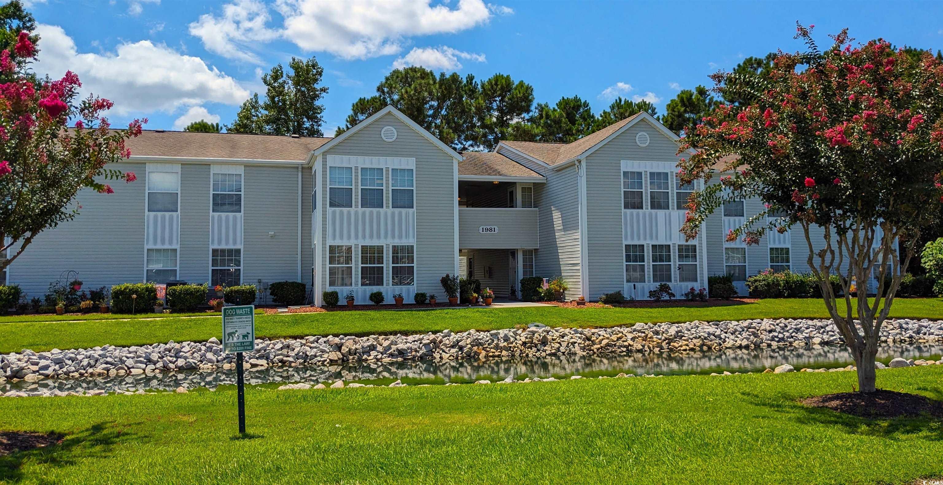 sweet first floor three bedroom condo not far from the beach, great restaurants, shopping and all beach living offers.  enter the foyer from breezeway and admire the grey vinyl plank flooring throughout the home. eastern exposure corner unit has lots of natural light in all rooms. breakfast bar for two looking into galley kitchen boasting granite countertops, stainless appliances and pantry. dining area with cutout for hutch or shelves.  large livingroom with ceiling fan opens to a carolina room with storage closet and view of lake with fountain and exquisite landscaping. 2nd and 3rd bedrooms have closets and view of lake. their bath with unique sink and vanity, double door tub. stone tile floors. master has corner windows, walk-in and linen closets its bath with stone shower surround and flooring, shelves behind door. unique double sinks and separate vanities.  laundry room has room for storage and larger stacked washer/dryer. handicap accessible unit. community pool, tennis courts, grill. low! hoa fees. building grounds with lush landscaping and palm trees. ez2c today.