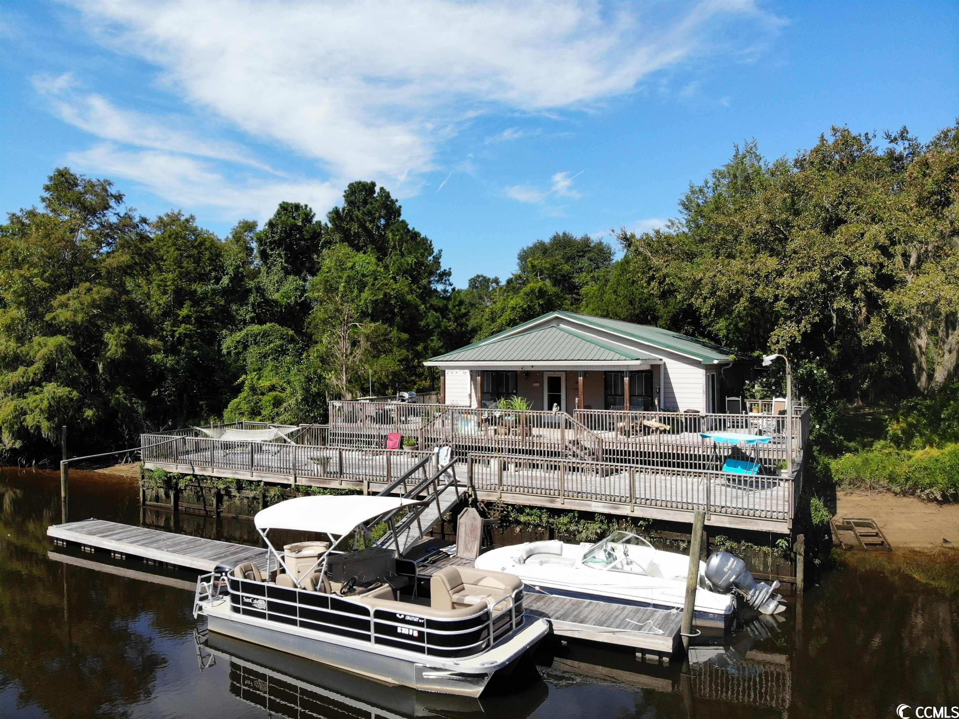 welcome to 33 boating lane, a hidden sandy island oasis that captures the essence of a rustic river cabin while embracing the allure of coastal living charm! step inside this four-bedroom, three-bathroom cottage spanning approximately 1800 heated square feet, where each detail exudes warmth and character.  this property is located on the back left channel that connects you to the backside lagoon of sandy island, but still very close to the intracoastal waterway.  a wildlife sanctuary of water and nature surrounds you, painting a breathtaking panorama, yet inside the home you will experience all of the modern-day pleasures of central heating and air, satellite tv, washer/dryer, full kitchen, etc.  as you approach, the heart of this retreat is unveiled—a sunbathing deck which wraps around three sides of the home. on the back left side deck, a heated and chilled pool is ideal for refreshing swims beneath the sun or stars. the remaining deck space is ideal for grilling, tanning, entertaining guests, or unwinding after a long day with your favorite beverage.  the lower-level deck connects the home to the floating dock making this area great for yard games, kid’s activities, or any other activity which deserves separation from the main deck area surrounding the home.  endless possibilities await with ample dock space on the floating dock that provides room for multiple boats.  through the recent hurricanes and storms, the main level has not seen flood waters breach the floorboards. it's a testament to the elevation and durability of this riverfront sanctuary. as you enter the front door, the spacious living room seamlessly flows into a generously sized kitchen equipped with a large breakfast bar and stainless-steel appliances. the open floor plan creates an ideal setting for entertainment, whether it be a large family gathering or a summer afternoon get-together after a day on the water.  peace and tranquility meet comfort in the master bedroom, with floor-to-ceiling views of the sandy island lagoon while lying in your king size bed.  there is also a walk-in closet along with dual sinks and stand-up shower in the master bath. the second bedroom could also be used as a master bedroom.  this large bedroom has an onsuite bath attached which is ideal for multiple families on extended stays.  the other two bedrooms are located off a small den.  these bedrooms share the third bathroom, ideal for guests, kids, etc.  convenience is key, as a full-size washer and dryer are also on site and included in the sale.  discover practicality in the detached storage shed, a versatile space for storing essentials and equipment. delve further to uncover another gem—an additional ground-level bathroom, currently being used for storage but has the potential to become a fourth bathroom, as this space is connected to the main house through a bedroom, which would enhance the convenience and comfort for your guests.  sold fully furnished, this retreat radiates comfort and style, with only a few treasured personal items excluded from the sale. this home's history as an airbnb listing for 2-3 years shines a spotlight on its potential for rental success, with detailed information available upon request.  please be aware that this unique location may necessitate alternative financing, beyond conventional means. this property is only accessible by boat so understand that advanced notice for all showings is imperative if you have any interest.  please contact the listing agent, or your realtor, for any additional information or to schedule a showing. there is a matterport virtual tour for this property that you may access prior to requesting seeing this property in person.