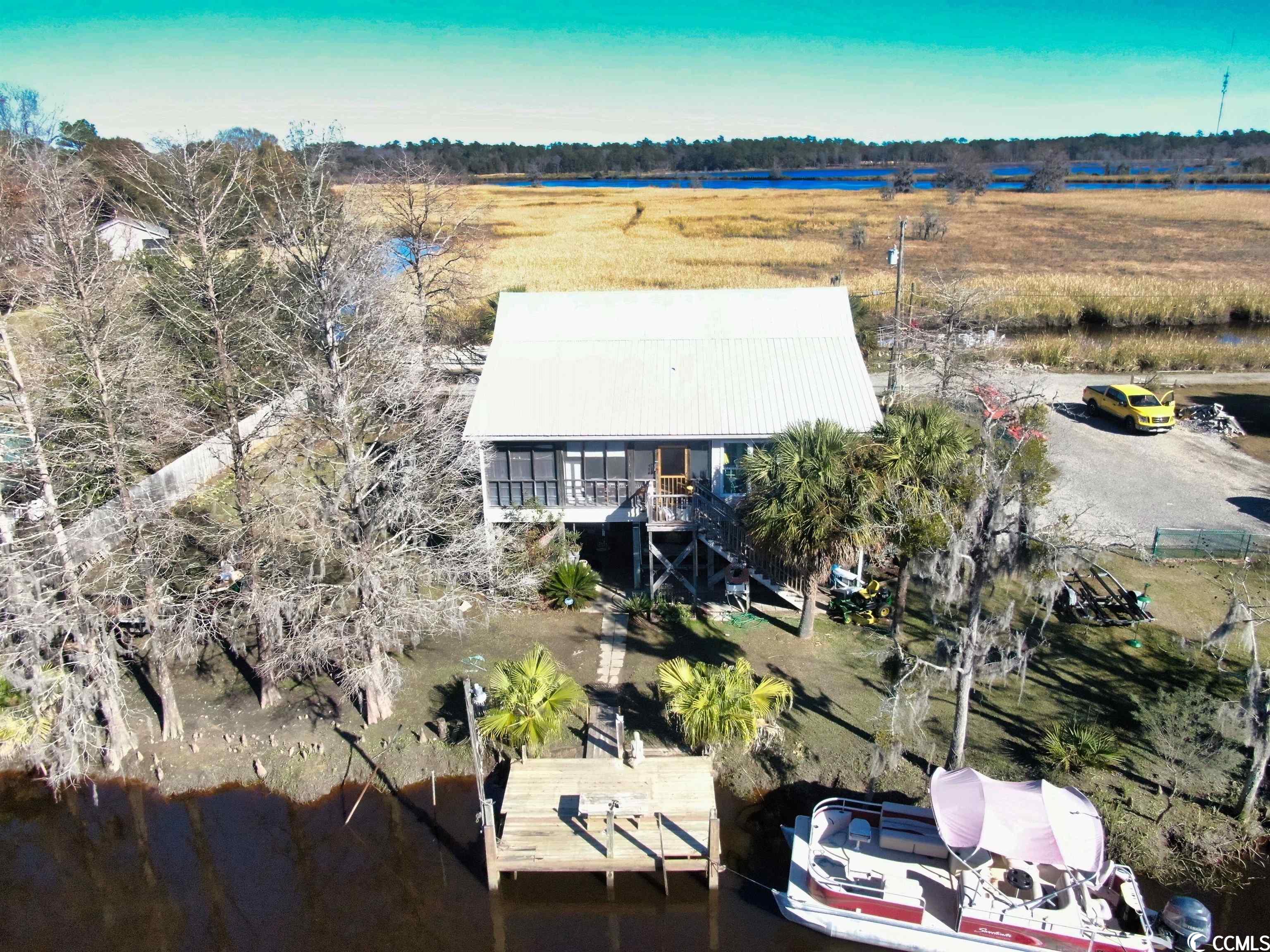 welcome to 72 catfish lane, a rare waterfront opportunity in the historic charm of georgetown, sc. this one-of-a-kind property offers a rare – dual waterfront access. surrounded by black river access on two sides, this home is a haven for water enthusiasts and nature lovers alike. whether you choose to journey by boat or car, the vibrant downtown georgetown is just a short distance away.  at the heart of this property are the two recently refurbished floating docks, one on each side of the house, perfect for boating enthusiasts. the front dock is equipped with 220 shore power and water, catering to all your boating needs. the deep-water creek/channel adds to the allure, promising endless aquatic adventures.  built in the classic raised beach style, this house boasts a rustic southern river house aesthetic. its open floor plan invites airy, comfortable living, ideal for a tranquil retreat, a lucrative airbnb rental, or a cherished primary residence. imagine relaxing on the serene front porch, overlooking the river and more than 100 acres of conservation ricefields and marsh land, where nature’s tranquility reigns supreme.  the interior is graced with hardwood floors, adding warmth and elegance to the space. the house features a spacious, enclosed carolina room at the rear, offering water views – a perfect spot for relaxation or entertaining.  additionally the hvac  recently replaced in 2021.  72 catfish lane is more than a house; it's a lifestyle, offering a perfect blend of waterfront living, historic charm, and modern amenities. it's an opportunity to own a piece of paradise, where the water is not just a view, but a way of life.