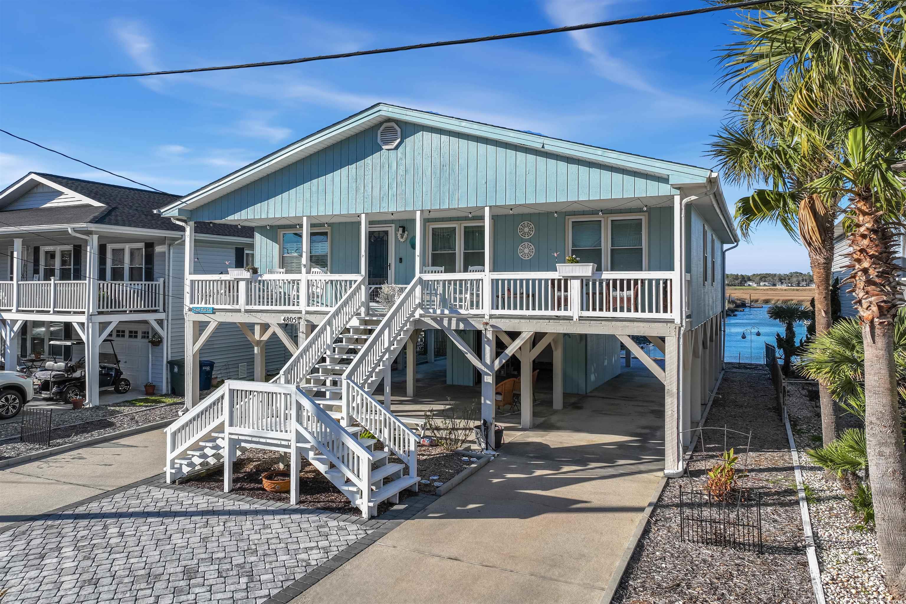 welcome to this peaceful oasis, perfectly situated at the end of a cherry grove channel leading to deep water access. this home has 4-bedrooms and 2-full baths, an elevator and 1 car private garage underneath this raised beach style home. the rear yard has a new 2017 seawall and beautiful paver-work with a matching pavered fire pit. a true treasure that offers breathtaking water views that define the essence of cherry grove living. the open floor plan invites you to spacious bedrooms adorned with recently upgraded flooring. the kitchen looks directly out to the channel through a panoramic view. enjoy upgraded features such as quartz countertops, a stylish backsplash, and stainless steel appliances. the master bedroom even has channel views from the master closet area. the roof was replaced in 2020, and a hvac system with fresh ductwork, there is also a generator for the property, all contributing to a modernized living experience. indulge in relaxation on the expansive covered porch, complete with rockers, where the soothing ocean sounds accompany glimpses of the waves. alternatively, savor tranquility on the back patio, soaking in the mesmerizing views of the peaceful channel. this home is a haven of comfort and coastal charm, seamlessly blending style with the allure of waterfront living. schedule a private showing today.