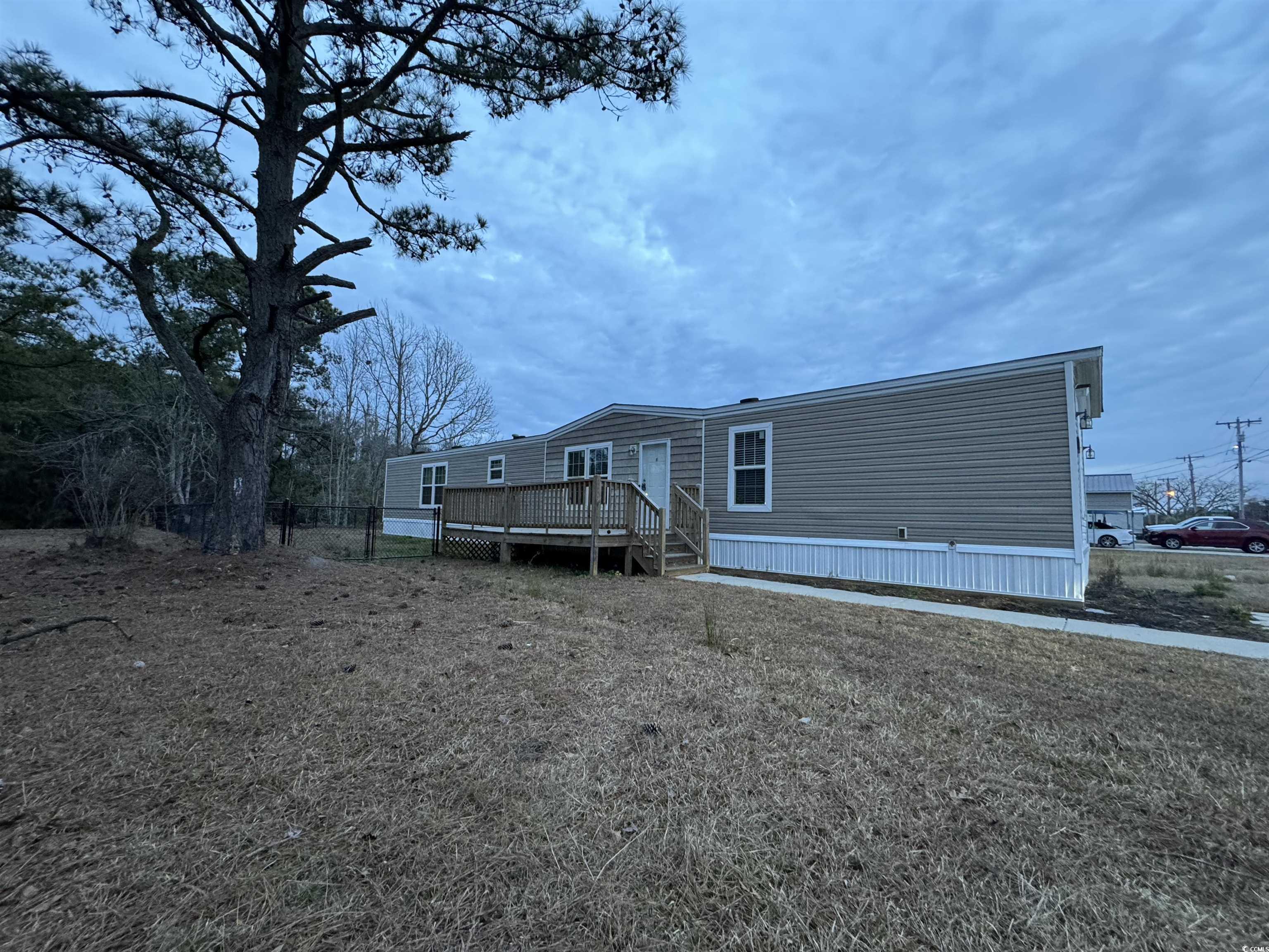 newer home in the grove subdivision only a golf cart ride to the beach with no hoa and not in a flood zone!  home offers three bedrooms, two full bathrooms, walk in closet, vinyl flooring throughout, large deck, fenced in yard, storage building and overlooking beautiful pond.