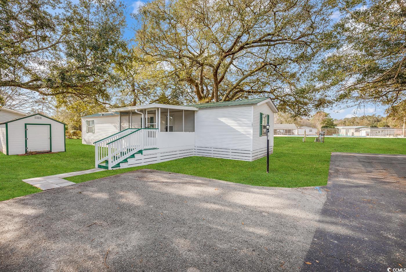here is your opportunity to vacation or live in this beautiful, totally renovated 2-bedroom 2-bath home located in the 55+ inlet oaks village community and only 1½ miles to the beach! all you need to do is move your furniture in and unpack. this lovely, immaculate home offers a newer a/c unit along with a metal roof. there is a spacious 2-car driveway to park your vehicles. walk up the few steps to the 12’ x 10’ screened in porch, where you will want to enjoy your morning tea/coffee or evening drink of choice. as you open the new front door, you will immediately appreciate the large open kitchen, dining, and family room. there are new low-profile led ceiling lights and new plantation blinds throughout the entire home. the kitchen has been completely updated with new stainless-steel appliances (fridge, range, dishwasher, microwave), plenty of charming white cabinets that offers a large amount of storage, new wide counter-tops and all new vinyl flooring throughout the entire home. family room has a beautiful credenza with an electric fireplace and a tv-wall mount directly above. walk towards the back of the home and you will see the new ge washer & dryer set. above the washer & dryer are overhead cabinets to store your laundry supplies. further down, the master bedroom has a lighted walk-in closet and an ensuite master bathroom with a garden tub. the second bedroom and full guest bathroom are in the front of the home. both bathrooms have new toilets, vanities, medicine cabinets, and over-the-toilet storage cabinets. flip the light switches two times to dim the lights for a softer atmosphere. outside you have a large wooden 12’ x 10’ shed with all new flooring, shelving, electrical outlets, and overhead lighting. in the shed is a new self-propelled lawn mower and weed wacker that will convey with the sale! the home is located at the end of the street and positioned on a shady lot for your added comfort. best of all, it is also located near the community swimming pool! home is being sold as is. inlet oaks village is a friendly 55+ community that offers many weekly activities and holiday parties at the clubhouse. there is a large 9 ft. deep swimming pool where the residents gather in the mornings for water aerobics. directly across from the park is a paved walk/bike path that will take you directly to huntington beach state park and beyond! all this is located directly next door to brookgreen botanical gardens and close to the famous marsh walk, shopping, dining and so much more!