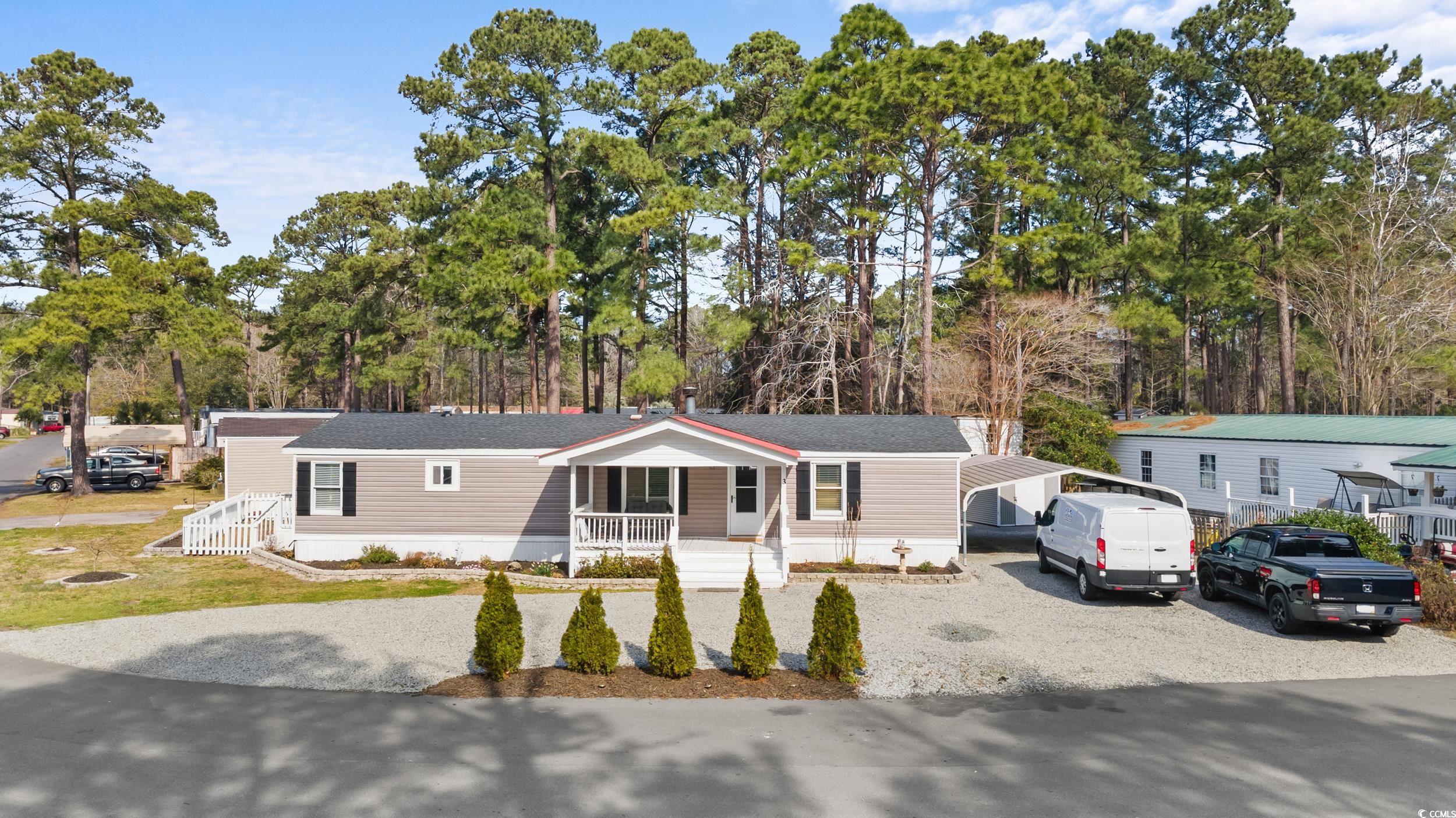 updated double-wide, 3 bedroom/2 bath with fireplace and large lot just a golf cart ride away from the beach!!! new siding and skirting 2022. fenced in back yard. new lvp flooring and sub-flooring 2023.  shiplap ceiling in primary suite. new gravel added 2024. hvac installed 2022. new metal roof 2019. recently repainted and new light fixtures & ceiling fans 2022. brand new microwave, dishwasher, mulch and blinds 2024. tile showers in both bathrooms and tile backsplash in kitchen and tile detail on fireplace. property includes 2 storage sheds and double carport as well as a screened-in back porch with hot tub. huge backyard deck for grilling out and entertaining. front porch recently added too. enjoy relaxing by the community pool on hot days. whether you are looking for a 2nd home, beach retreat or permanent residence, don't let this one get away. close to everything including the famous marsh walk, excellent restaurants, medical and don't forget about the beach...only a few minutes away by golf cart!!! no hoa. see info regarding monthly land lease. buyer responsible for verification of all square footage and mobile home park information.