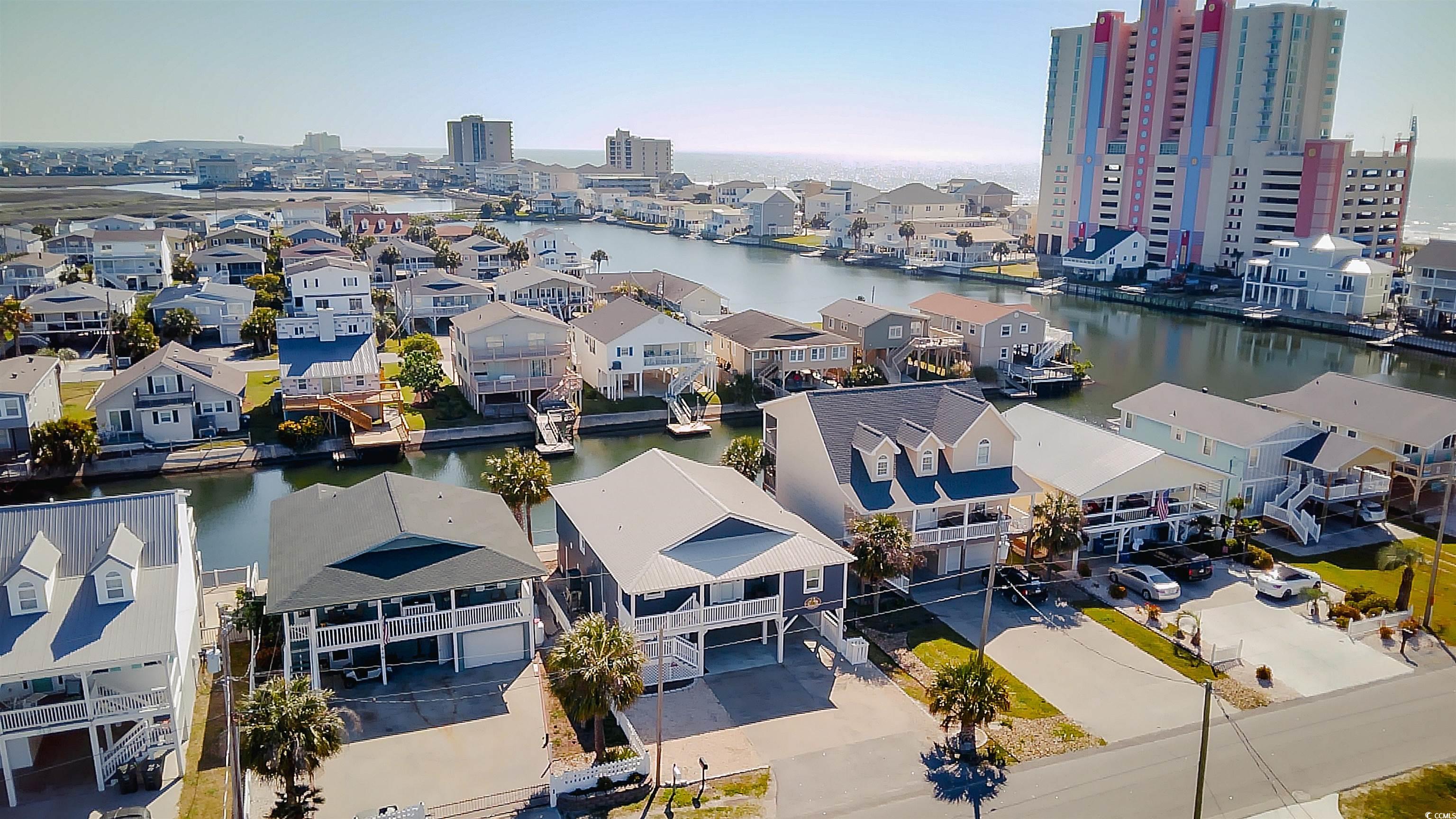 welcome to coastal living at its finest at 310 34th ave n! this spacious 5 bedroom 3 bathroom raised beach house has no hoa! sitting on a salt water channel, it is swimmable all summer and fishable all year.  the perfect backdrop for family get togethers or social swim and barbecue parties. as you step inside, the allure of this home is immediately apparent. the kitchen, adorned with stylish stainless steel appliances, a convenient work island, and abundant counter and newly updated red oak cabinet space, is a culinary enthusiast's dream. whether you're whipping up a quick meal or hosting a gourmet dinner party, this kitchen is as functional as it is fashionable. upstairs, four generously proportioned bedrooms await, thoughtfully laid out for both comfort and convenience. with two full bathrooms nearby, mornings are a breeze, and evenings are a retreat. the formal dining room offers a picturesque backdrop of the water, creating an ambiance that elevates every mealtime experience. step outside onto the back balcony, where sweeping views of the inlet provide the perfect setting for entertaining guests or simply unwinding in serenity. additional outdoor spaces abound, including a front balcony complete with a lift, ideal for soaking in the sights and sounds of the neighborhood. venture downstairs to discover a versatile space, perfectly suited for an in-law suite or separate apartment. complete with its own kitchen, living room, and full bathroom, this area offers endless possibilities. a workshop adds practicality to the lower level, providing ample space for diy projects or hobbies. outside, the allure of waterfront living continues with a deck, and spacious covered patio. whether you're fishing, lounging, or hosting gatherings, this outdoor oasis promises endless enjoyment. upgrades this home features is a roof installed in 2020,  a/c, air handler, and ductwork in 2021, and a propane powered tankless water heater in 2023.  the location of this coastal retreat is unparalleled, offering the best of both worlds. within walking distance to cherry grove beach and mere minutes from the intracoastal waterway, barefoot landing, premier golf courses, shopping destinations, and a vibrant array of dining and entertainment options, every day presents a new adventure. don't miss out on this rare gem on the water! book your showing today!